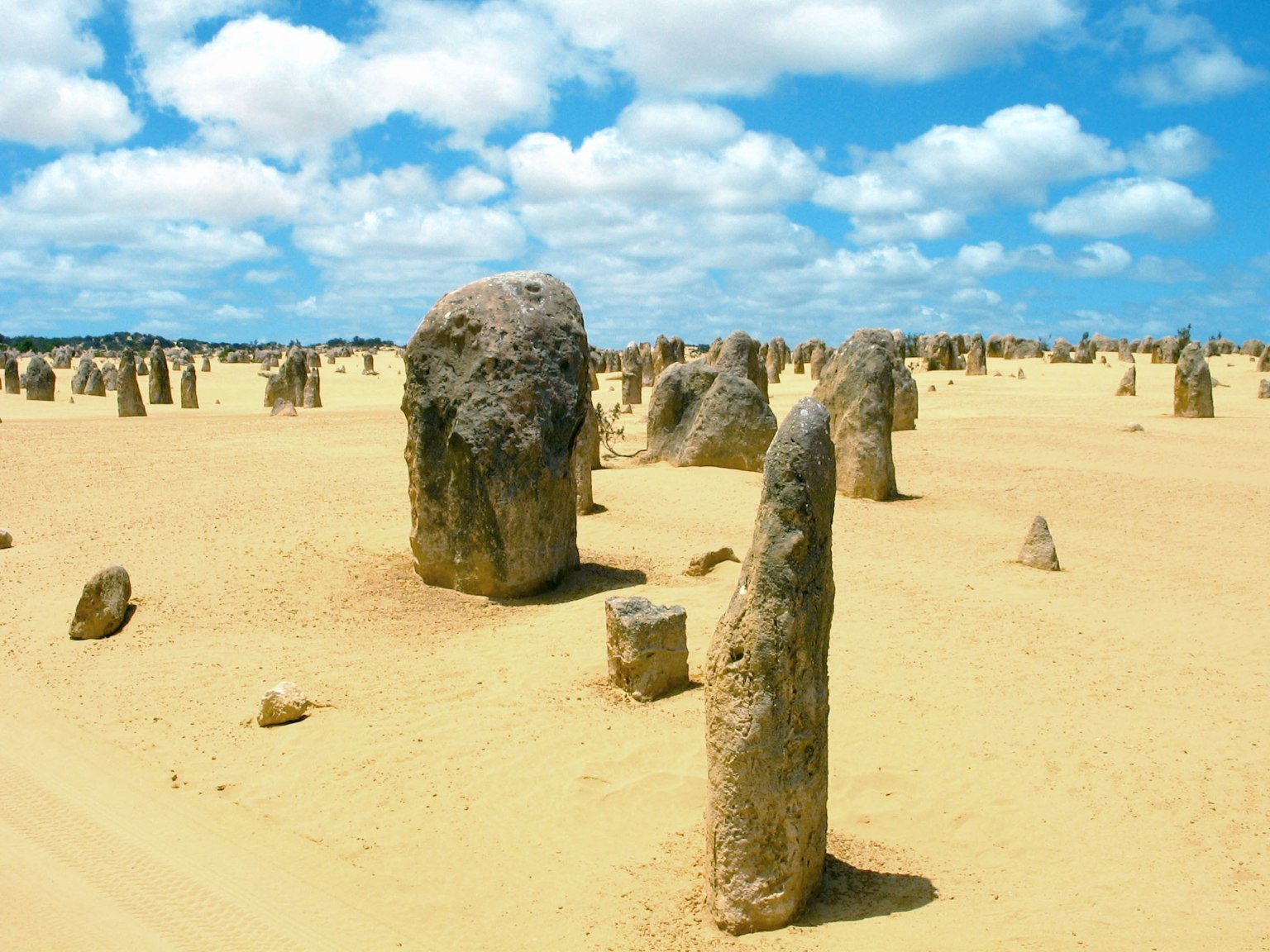 Un vasto paesaggio desertico con numerosi pilastri di pietra e un cielo blu
