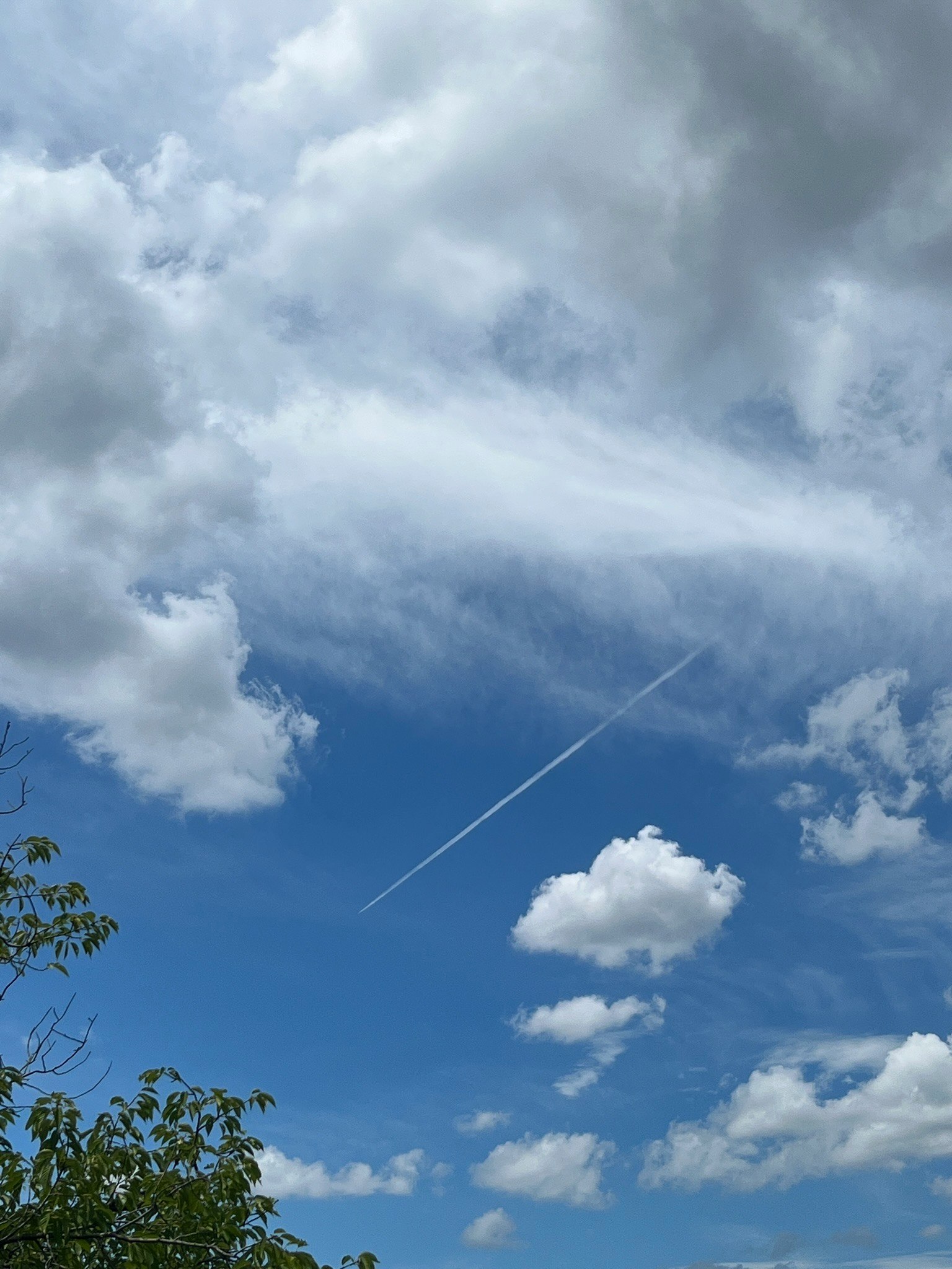 Vista panoramica del cielo blu con nuvole bianche e una scia di aereo