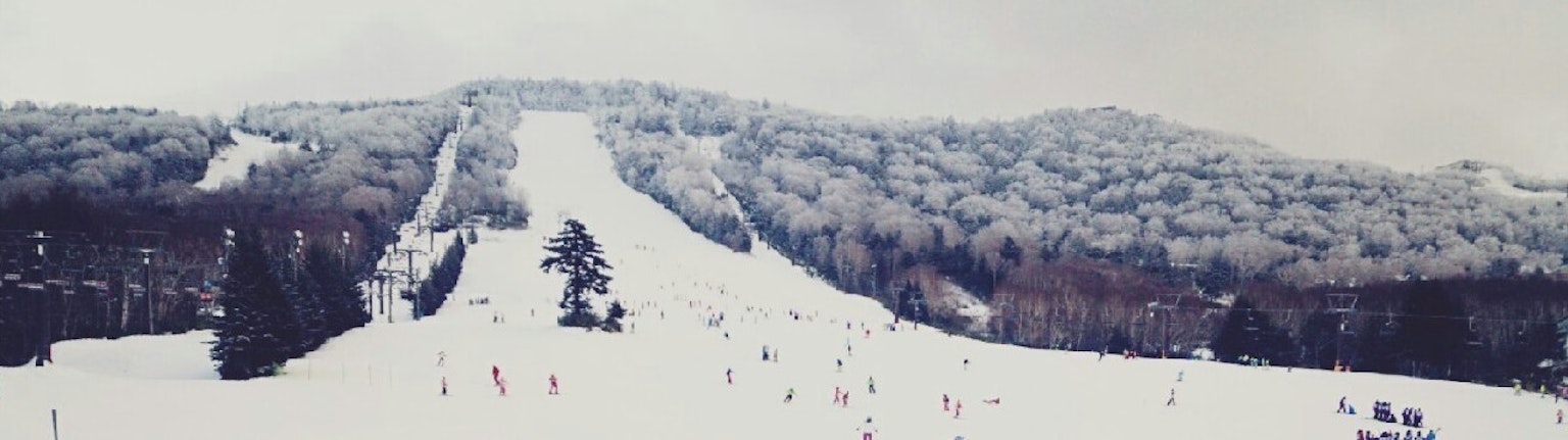 雪覆盖的滑雪度假村景观 有滑雪者和滑道