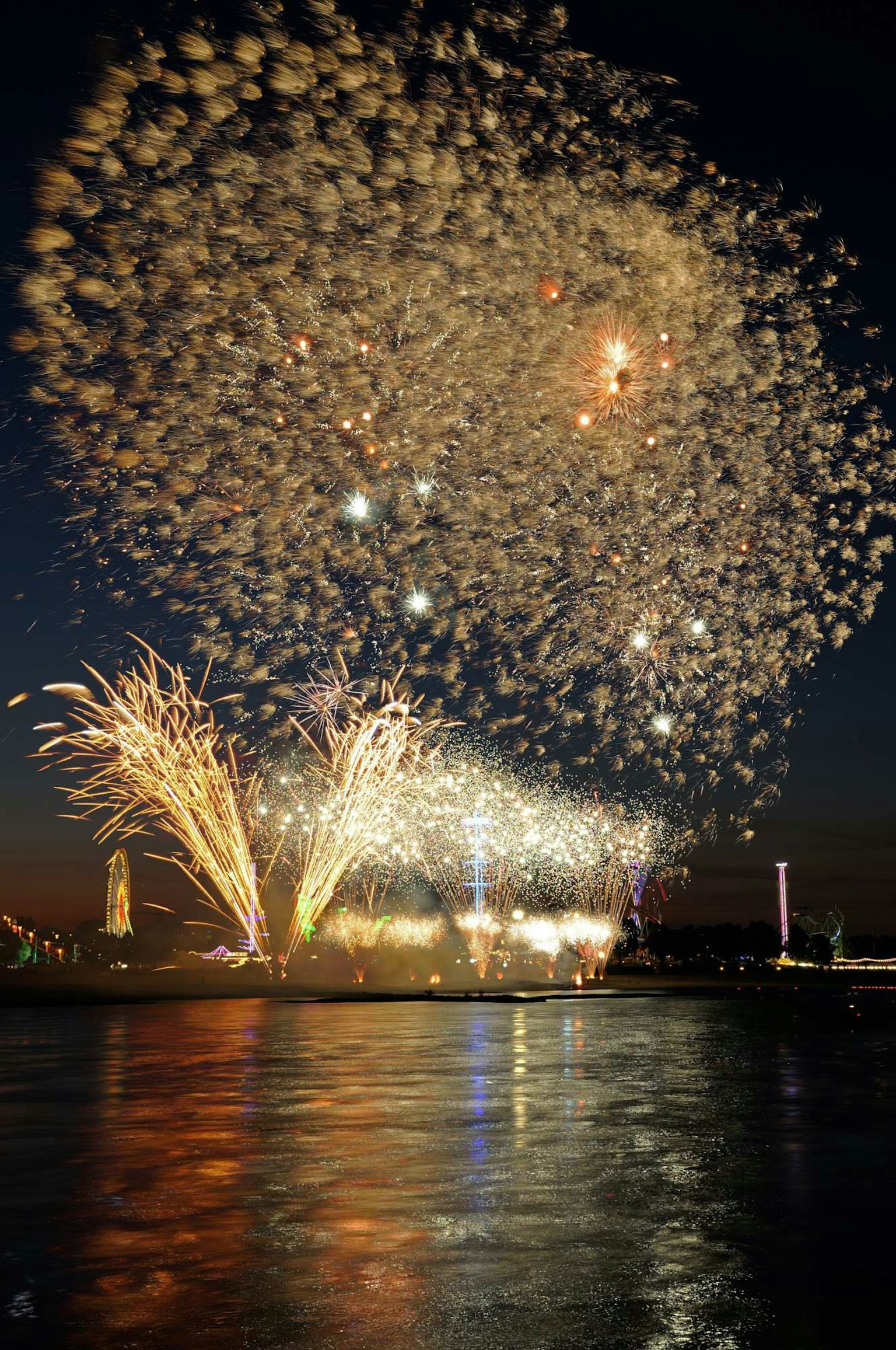 Spectacle de feux d'artifice illuminant le ciel nocturne réflexions sur l'eau