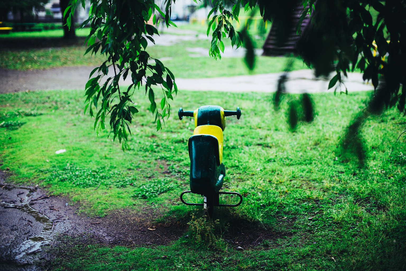Equipo de juegos verde y amarillo en un área de césped del parque