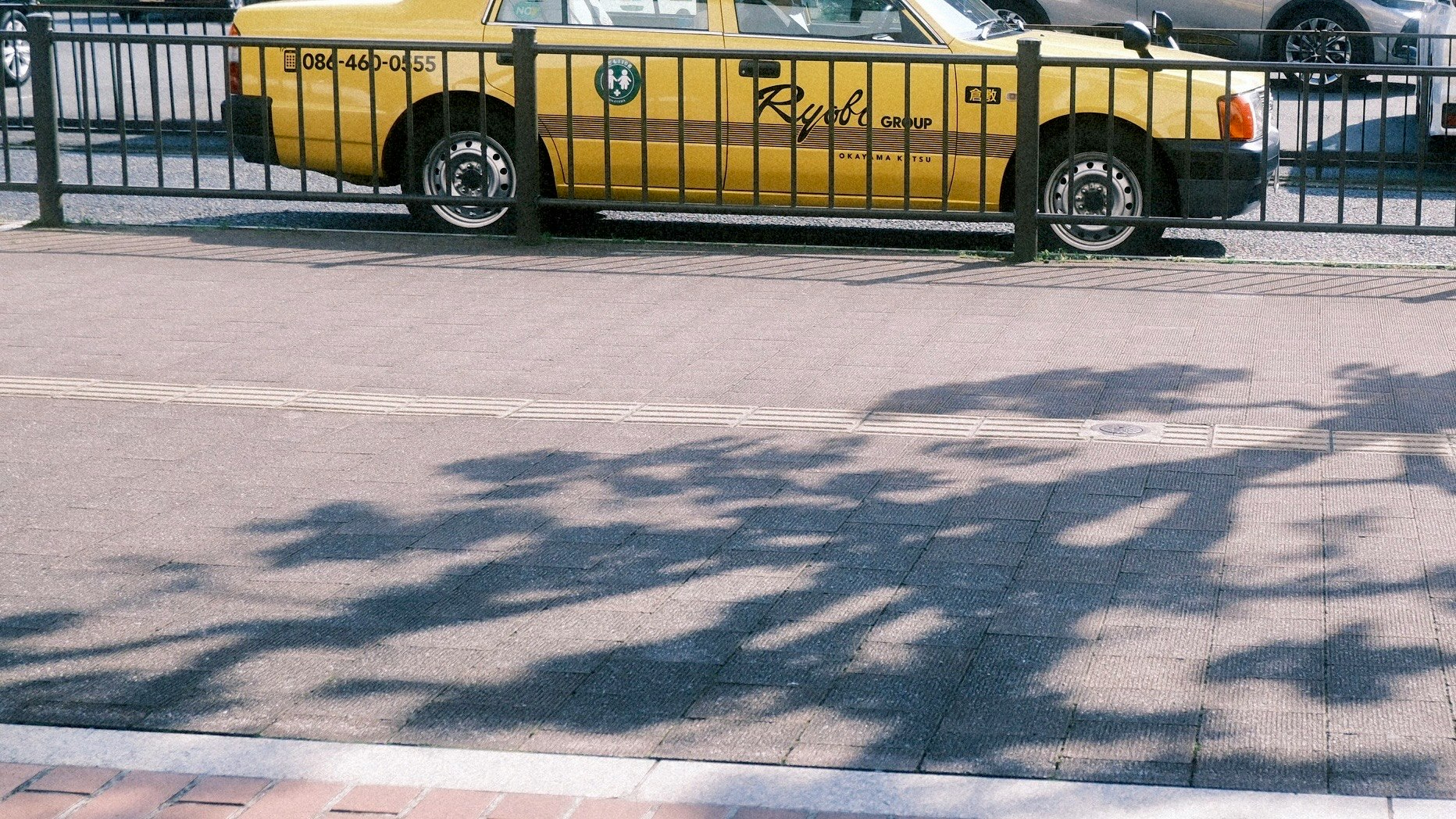 黄色い路面電車のある街角の歩道