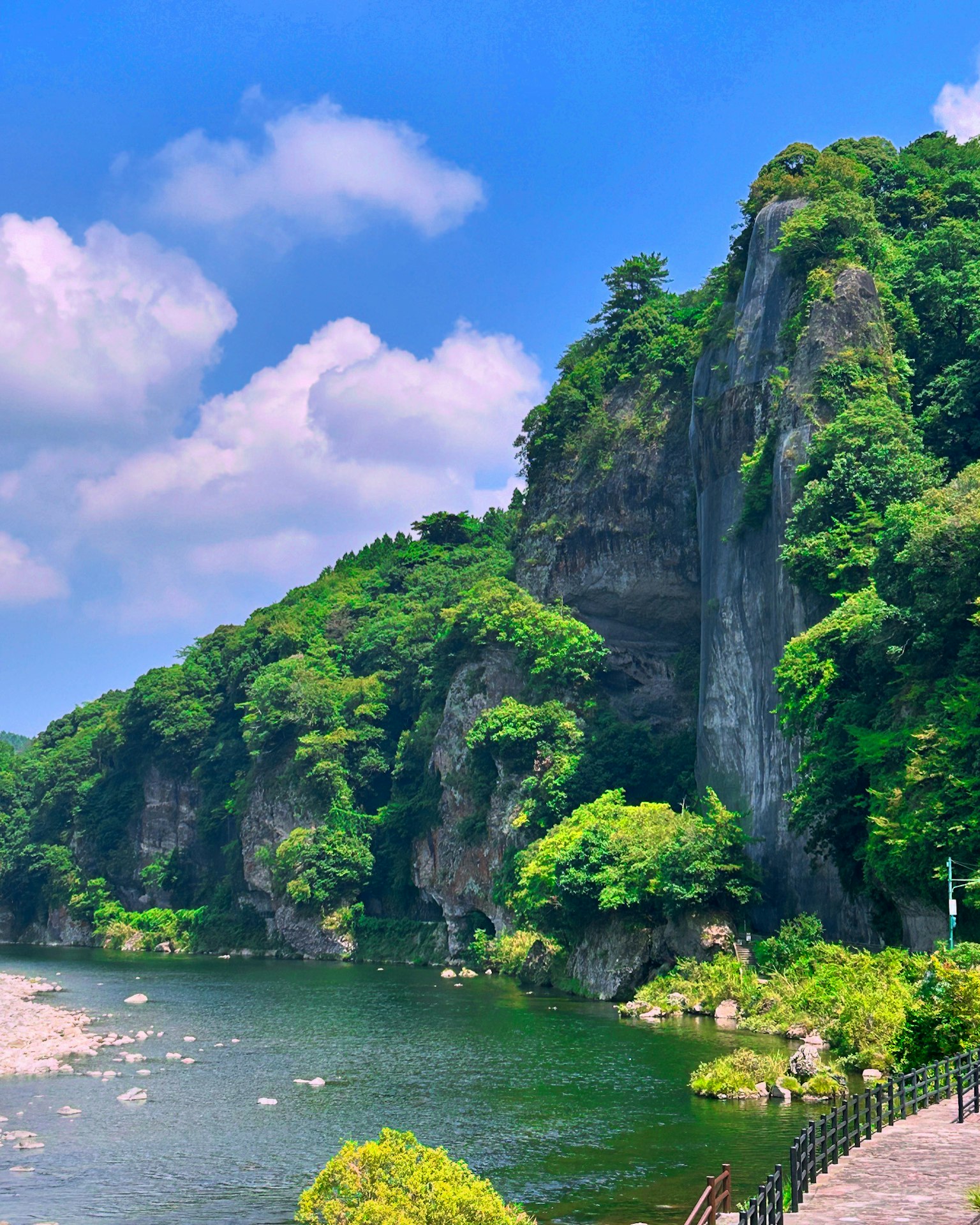 Montagnes verdoyantes et ciel bleu clair sur un paysage fluvial