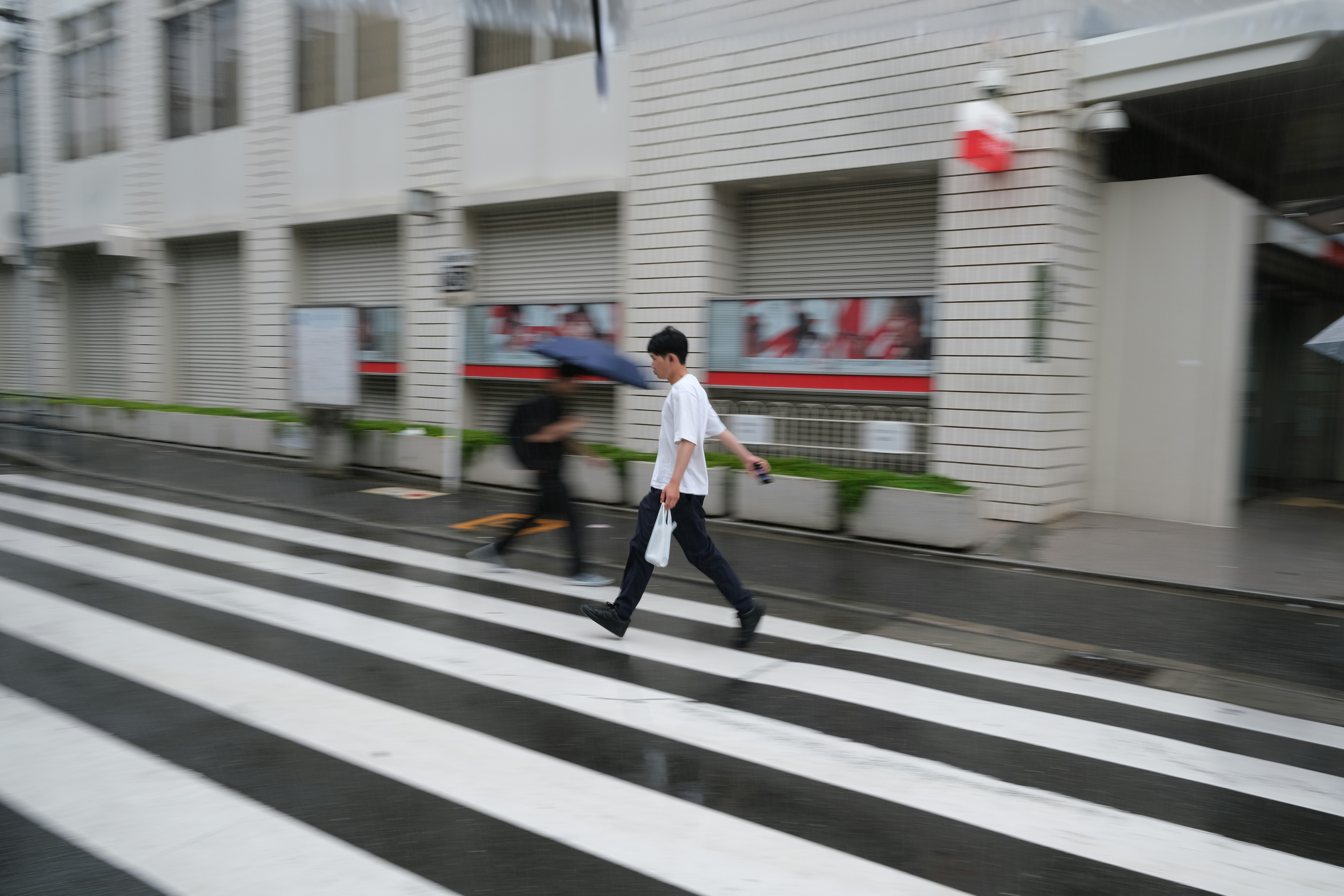 横断歩道を歩く人とビル街の背景
