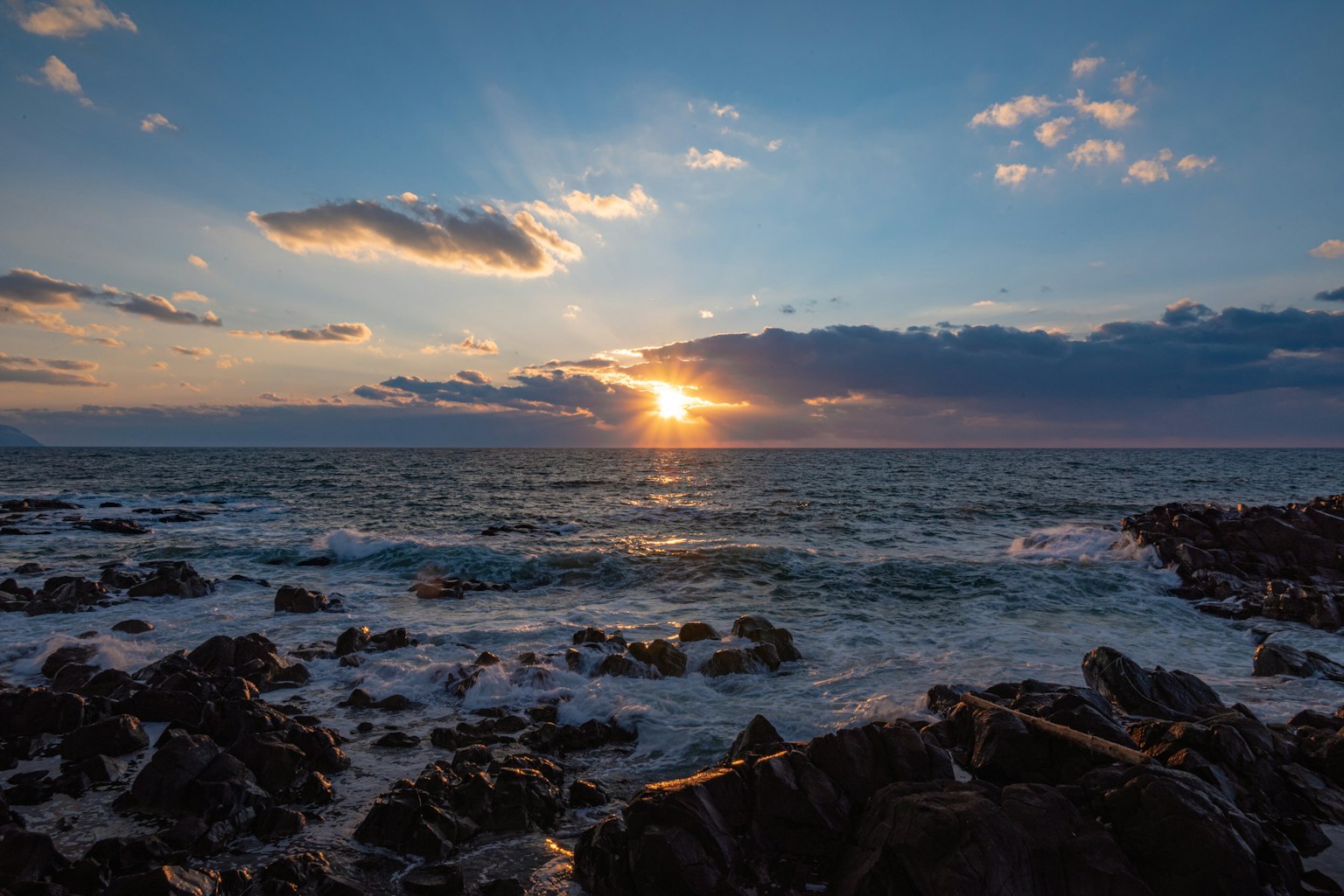 海洋上夕阳西下的美丽景色与岩石岸边