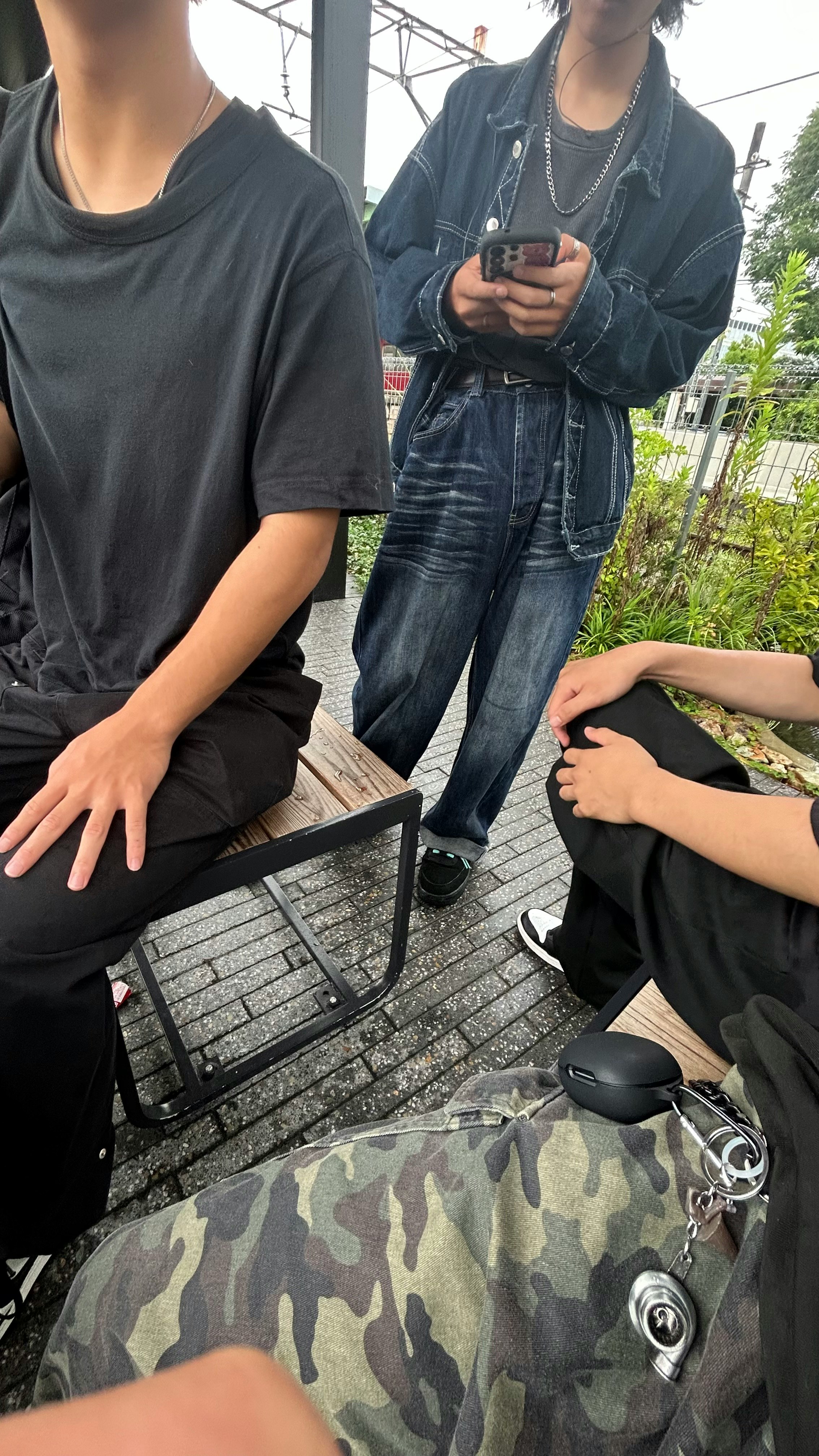 屋外のベンチでスマホを見ながらくつろぐ人たち
