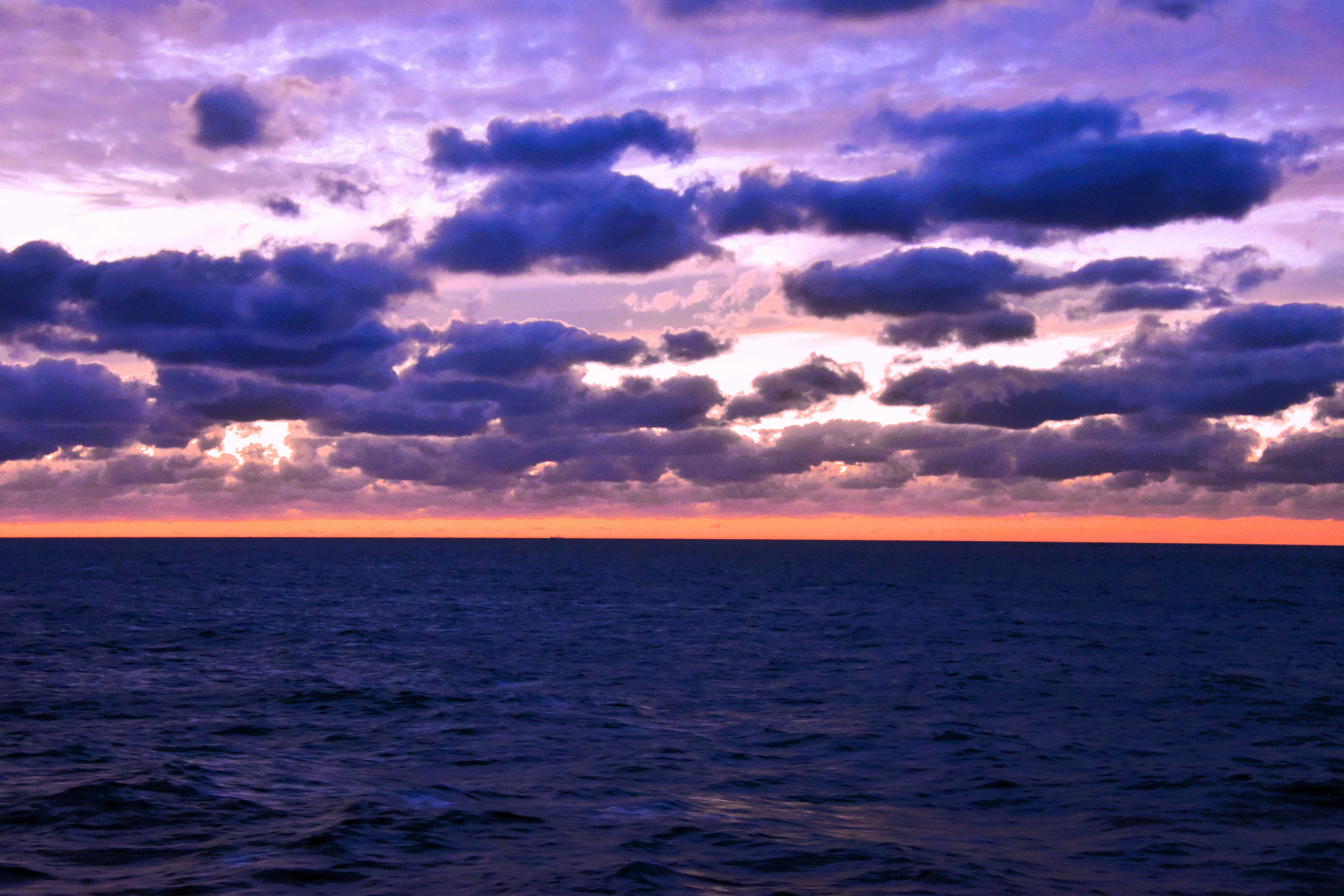 水平線に広がる海と夕焼けの雲景