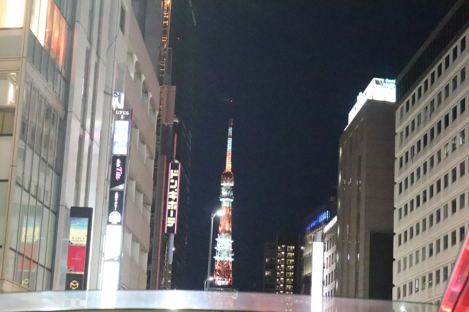 Tokyo Tower nachts beleuchtet zwischen Stadtgebäuden