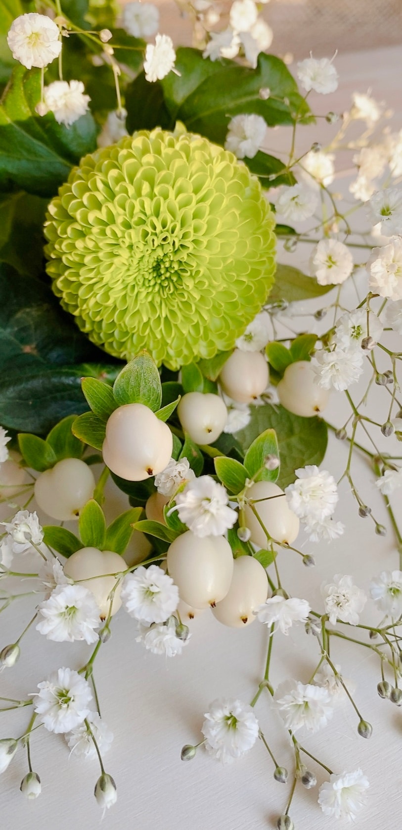 arreglo floral con flores blancas y una flor verde
