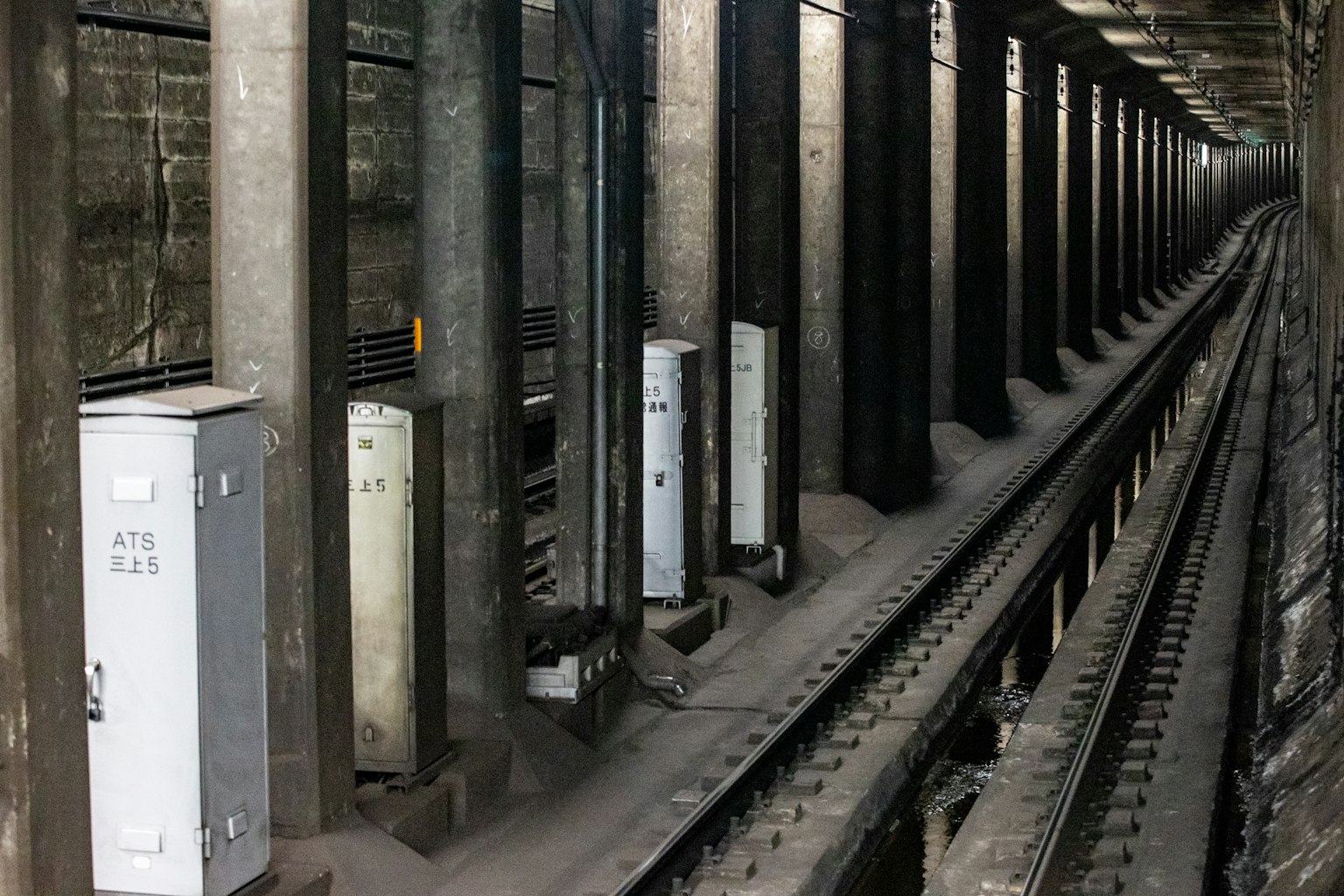 U-Bahn-Tunnel mit Reihen von Säulen und Schaltkästen