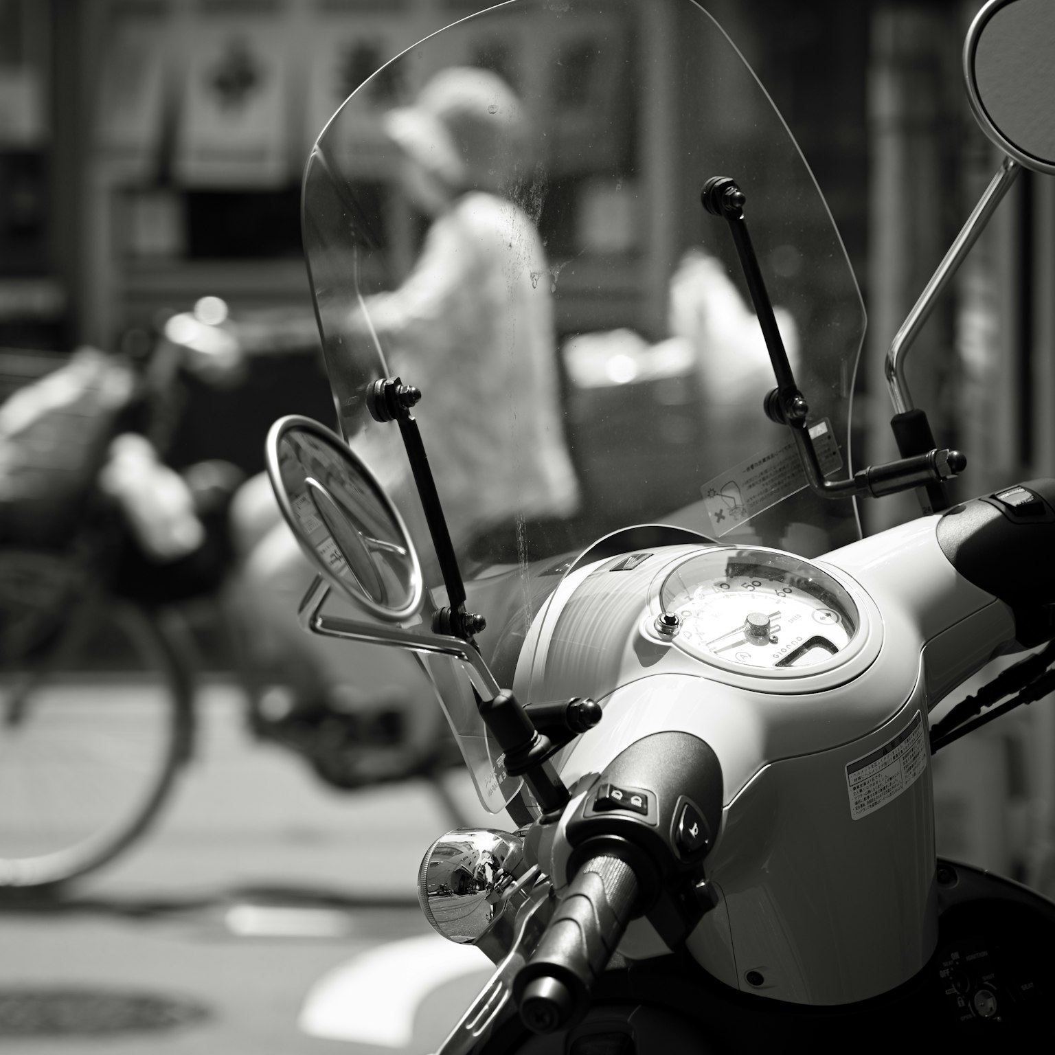 Primo piano di una moto con pedoni sfocati sullo sfondo