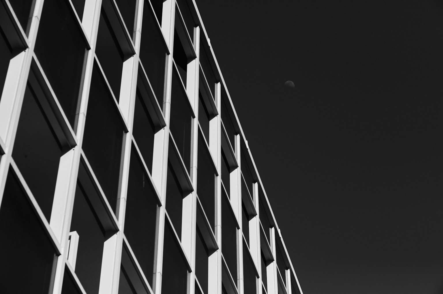 Diagonale Ansicht eines modernen Gebäudes in Schwarz-Weiß mit markanten Fensteranordnungen