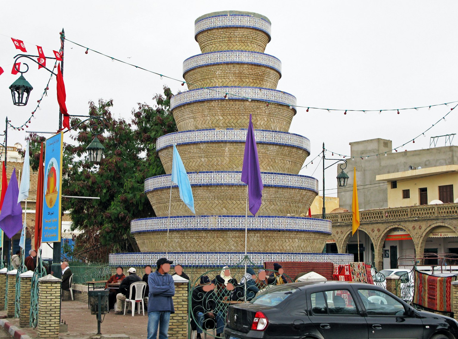 Structure de fontaine décorative au centre-ville avec des personnes autour
