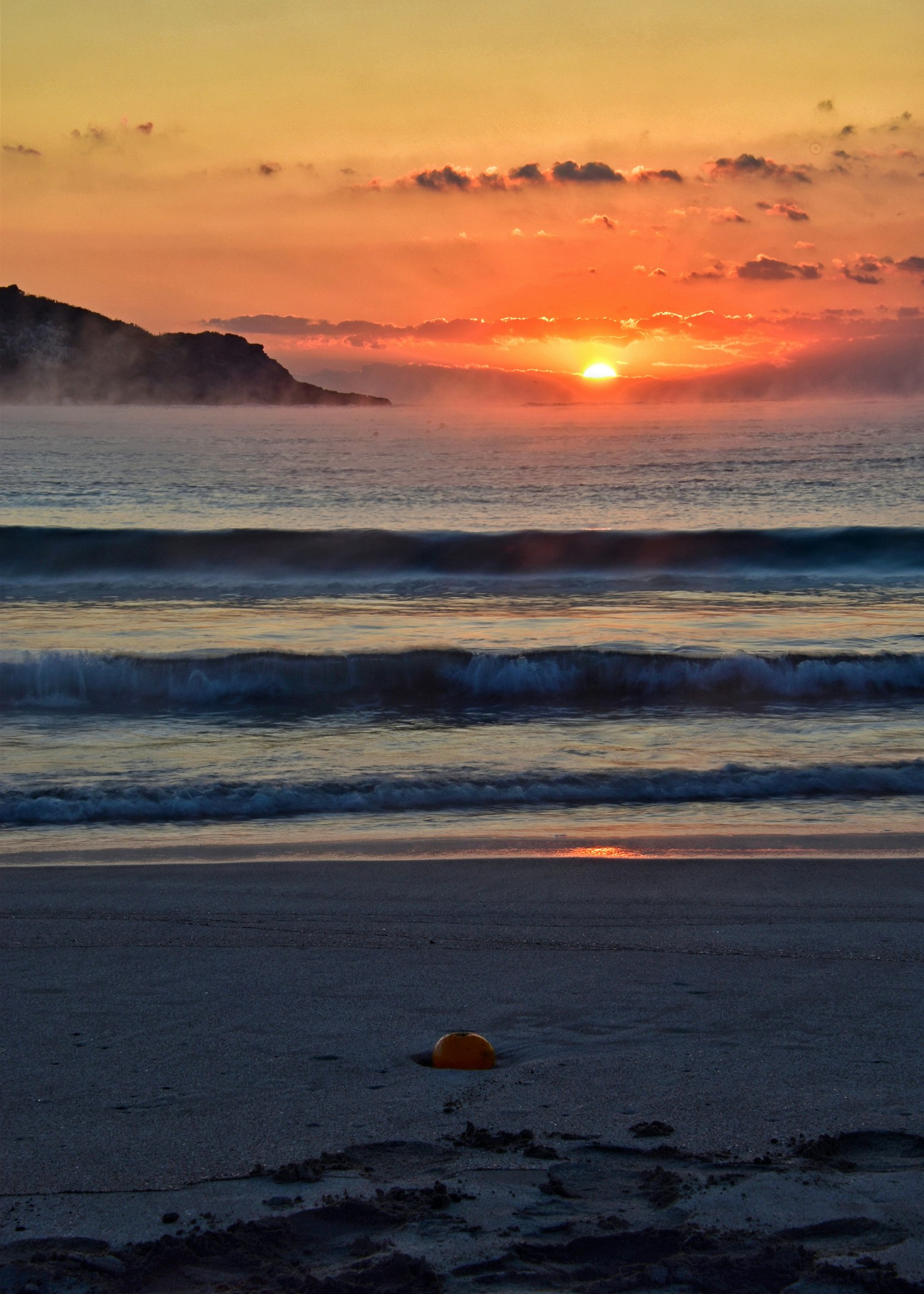 Beautiful sunset over the ocean with waves and a beach
