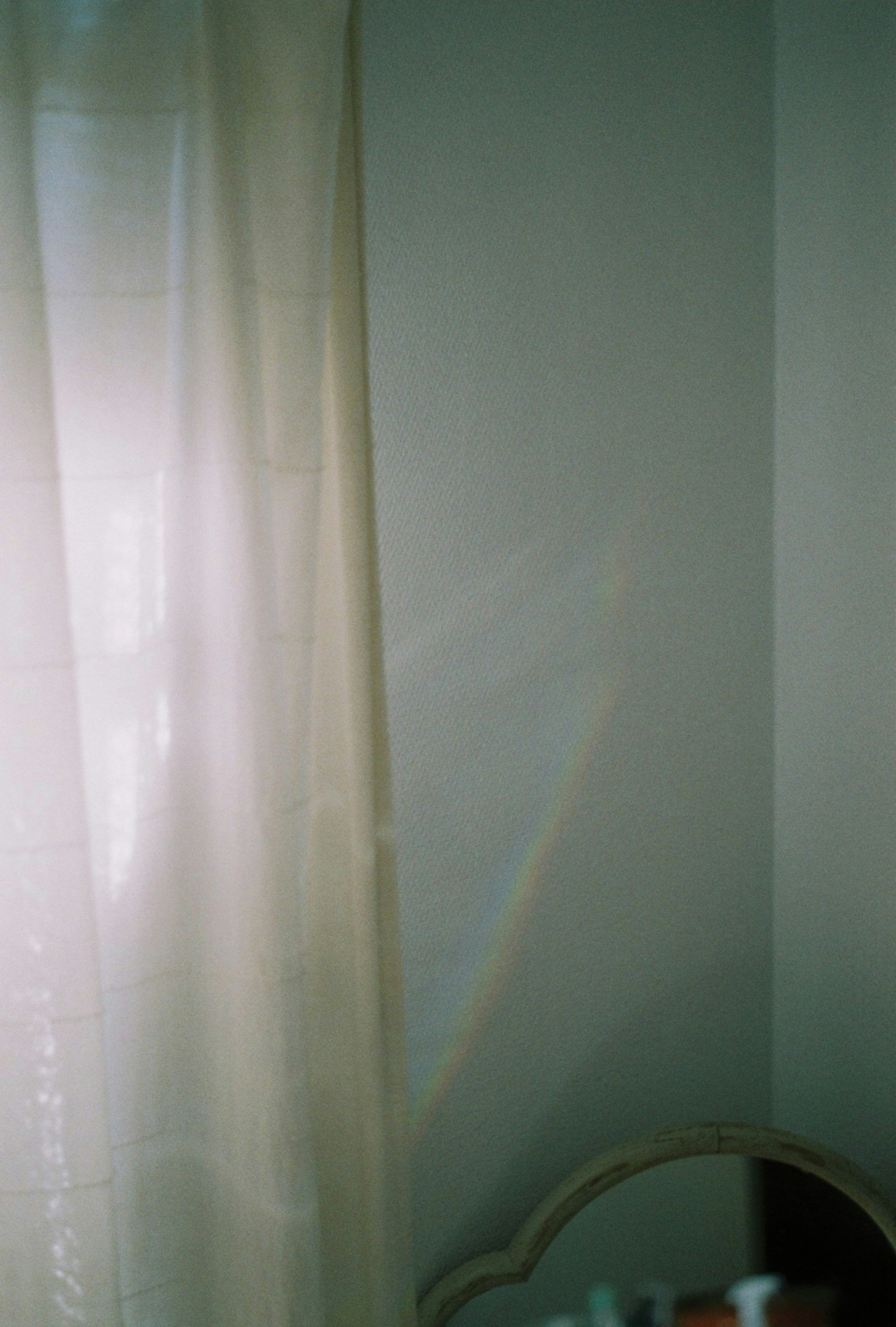 カーテン越しに差し込む柔らかな光が壁に映る様子