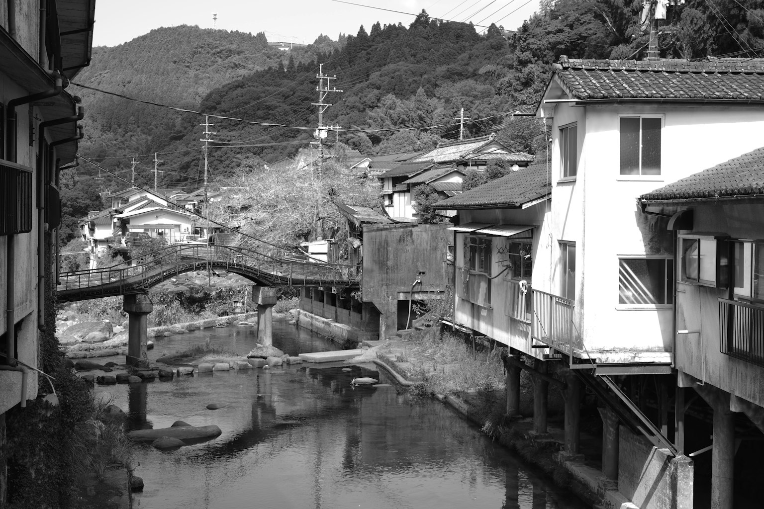 Black and white photo of an old town with a river and traditional buildings