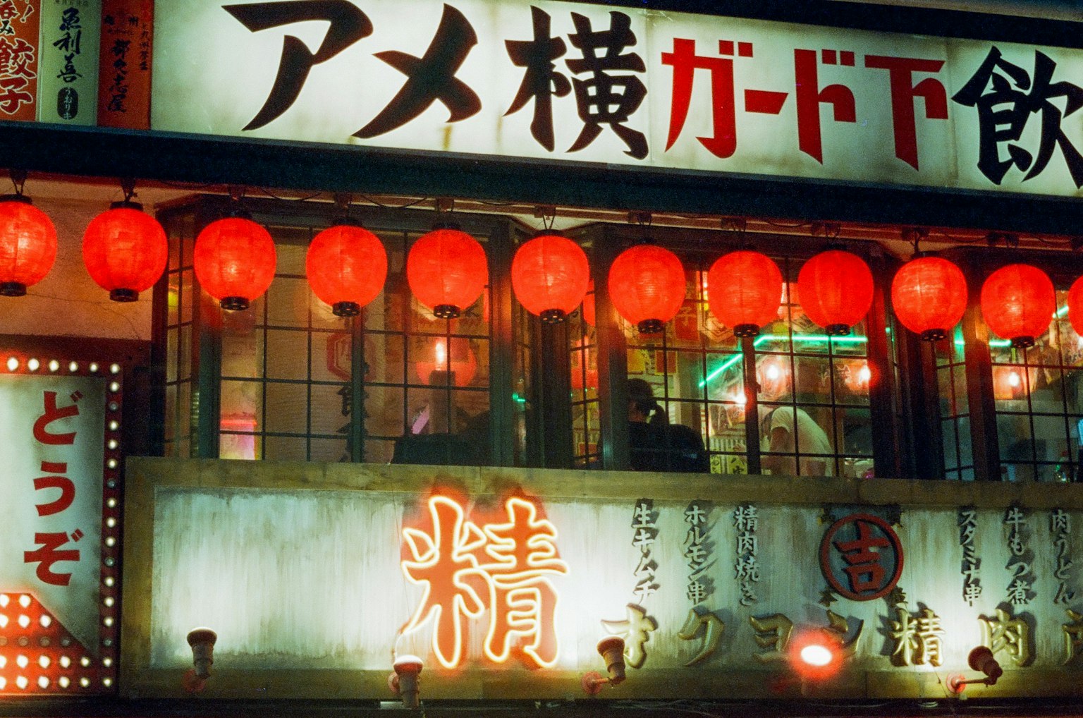 充满活力的餐厅外观，红灯笼和阿美横丁的招牌以及日文文本