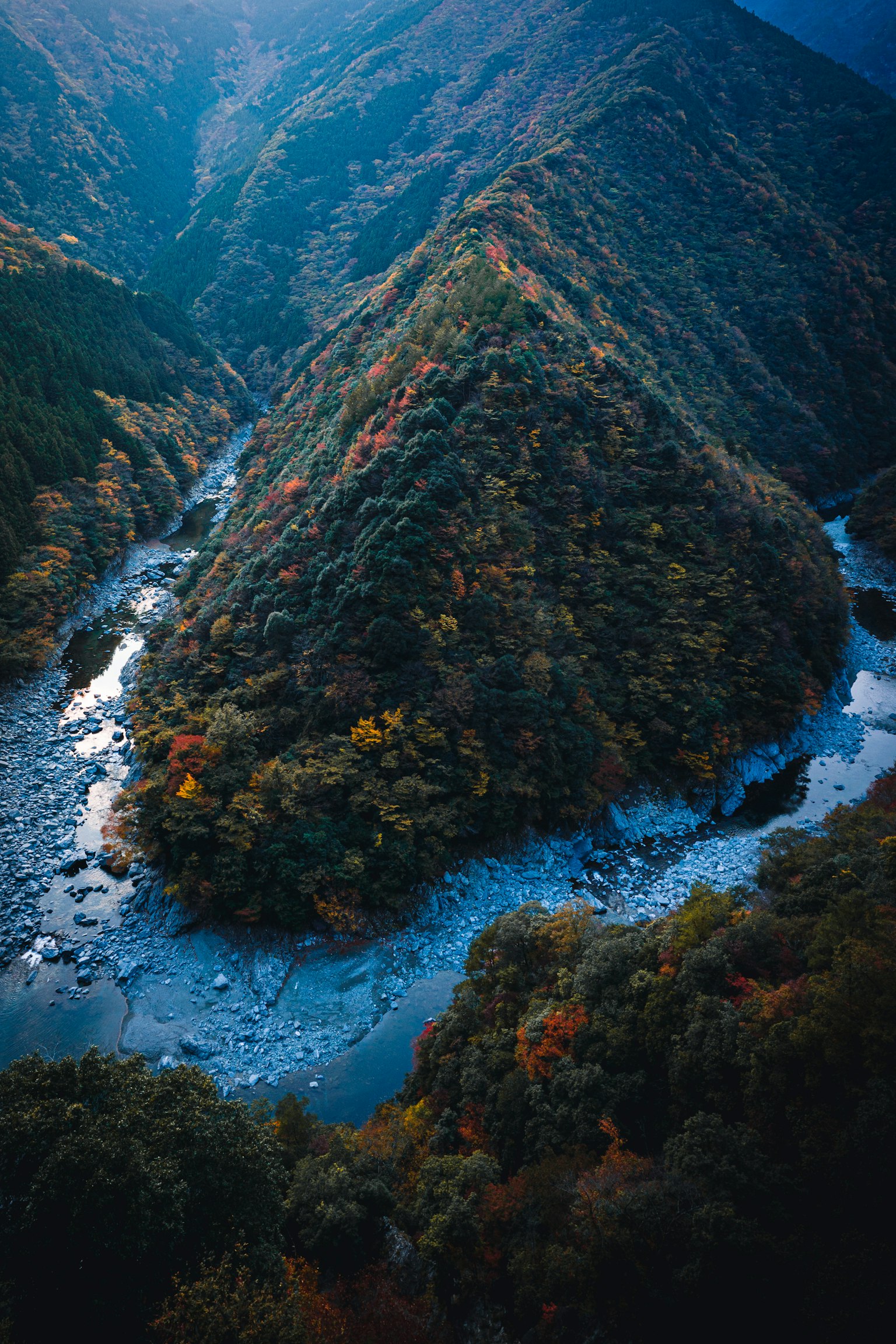 Vue pittoresque d'une rivière sinueuse entourée de feuillage automnal coloré et de montagnes