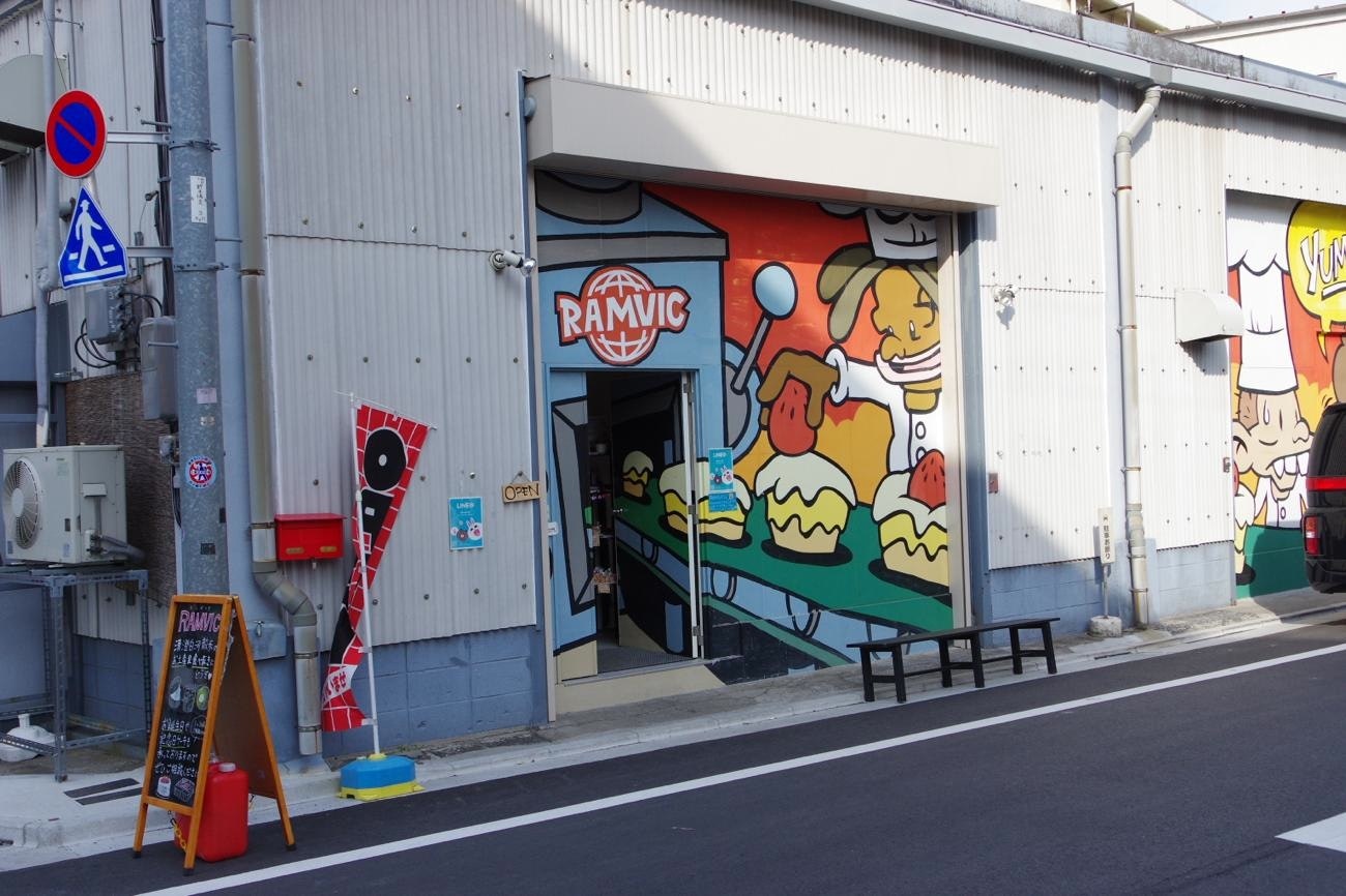 路地の壁に描かれた大きなキャラクター壁画のある入口