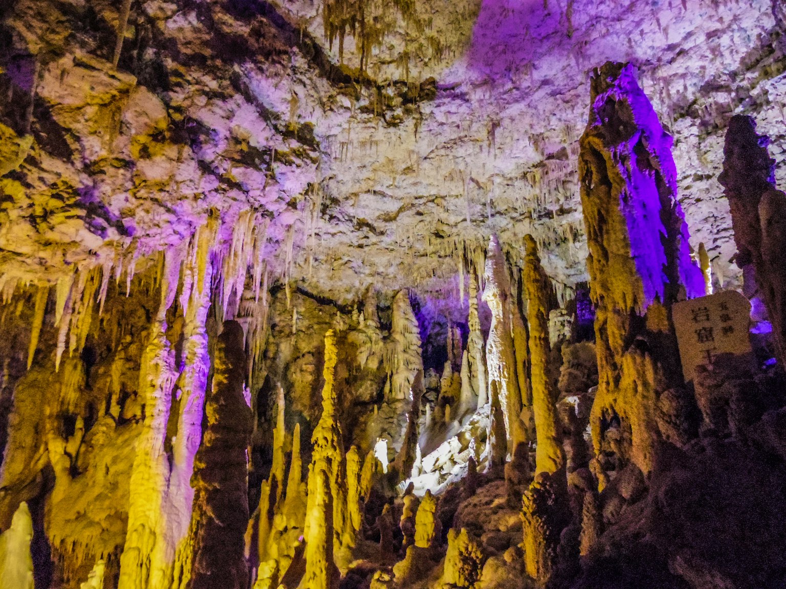 Intérieur d'une grotte avec des stalagmites et un éclairage coloré