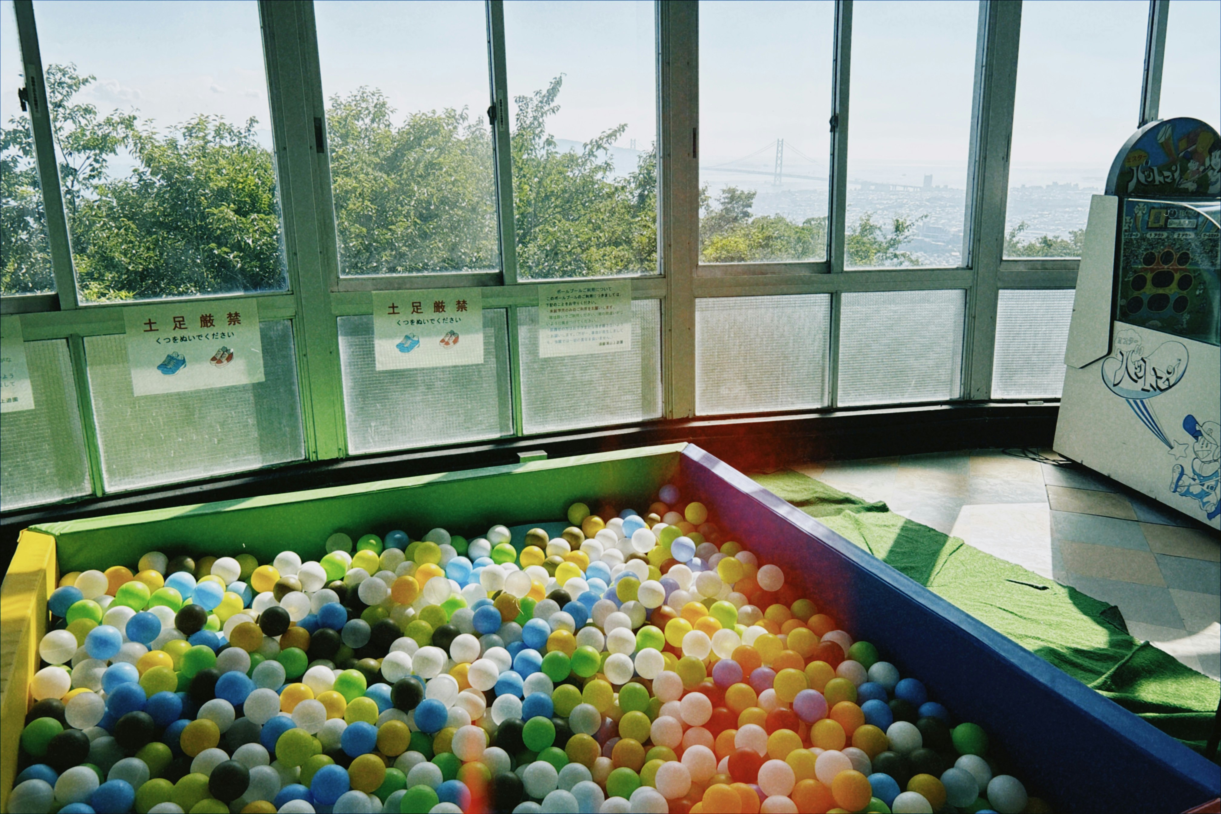 Piscine à balles colorée dans une aire de jeux intérieure avec de grandes fenêtres
