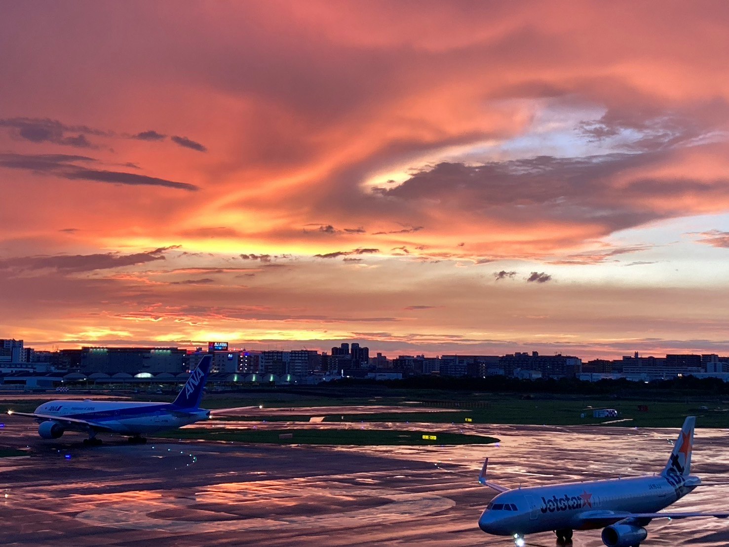 夕焼けの空港滑走路と旅客機のある風景