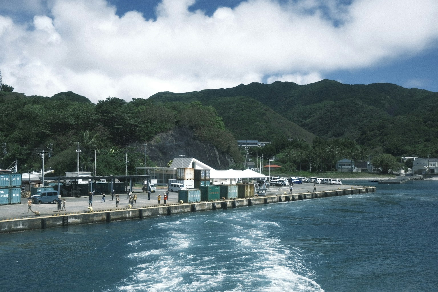 海岸港口背景有山脈船隻出發