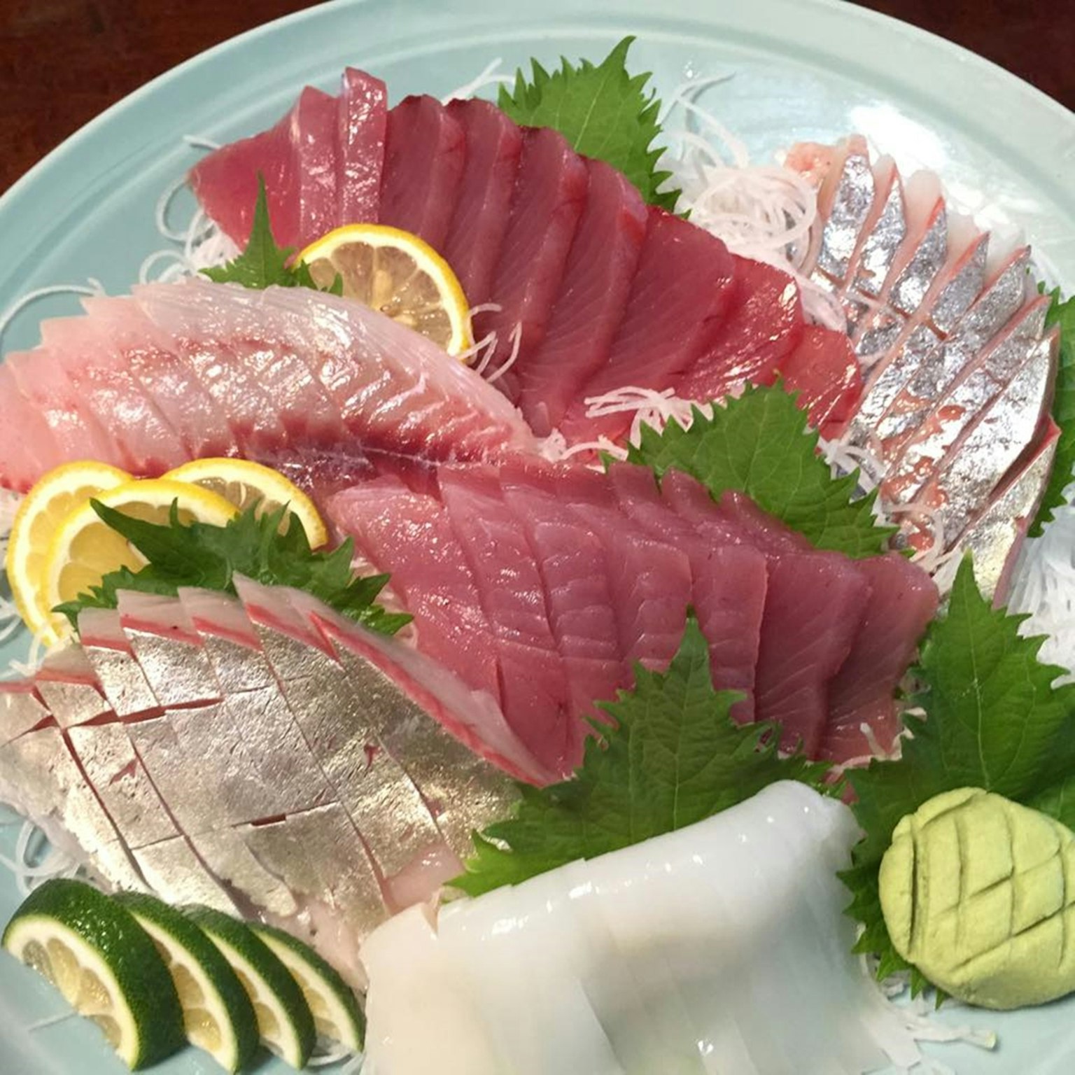 Plato de sashimi colorido con rodajas de cítricos