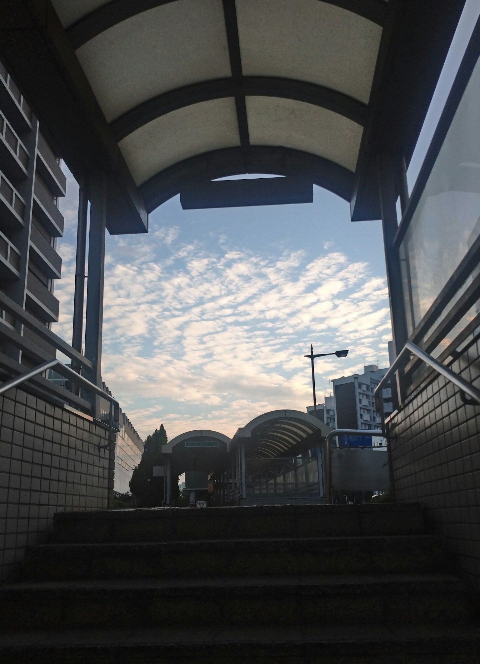 Arco che conduce a un cielo blu con nuvole sopra la scala