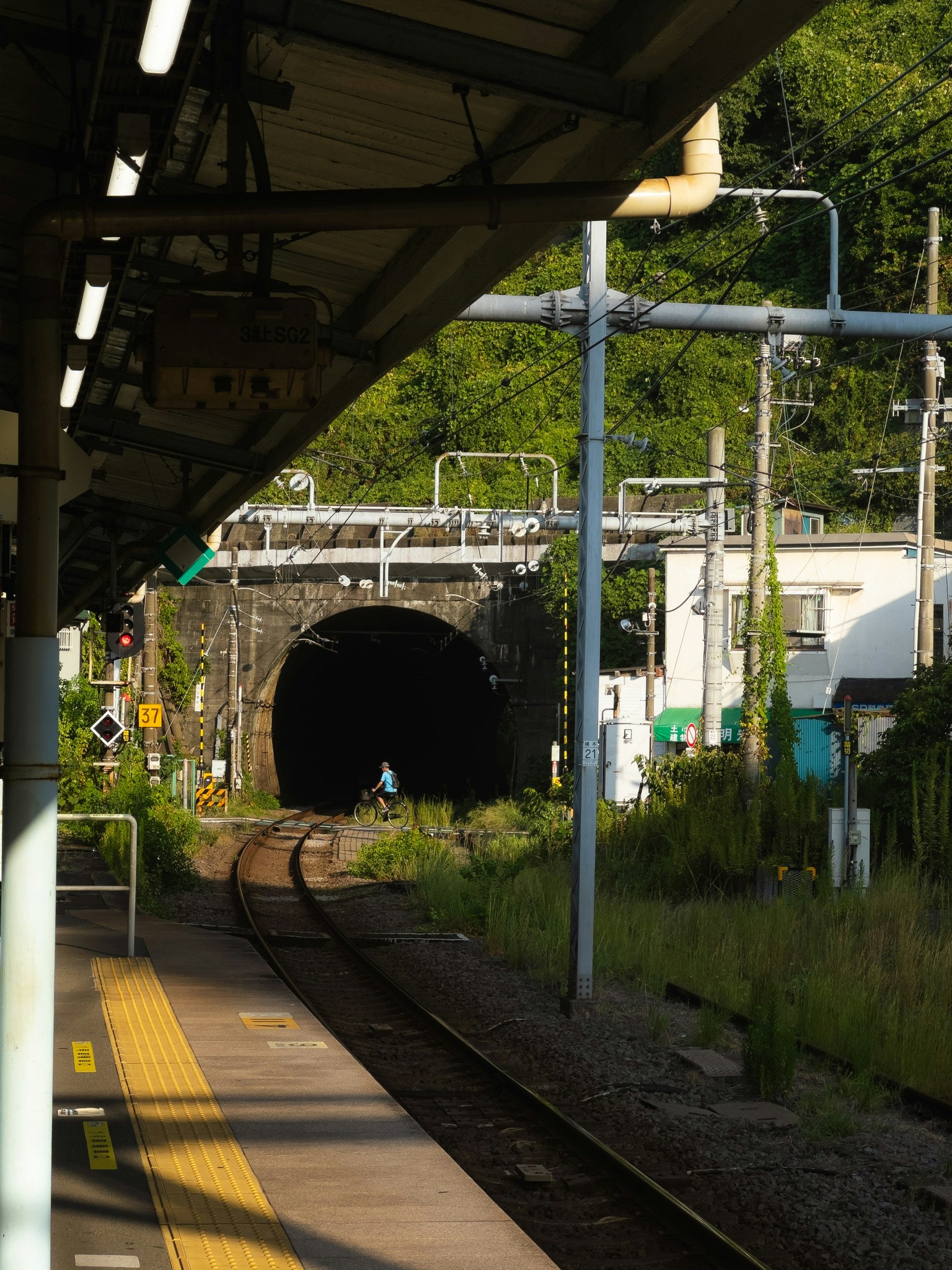 駅のプラットフォームから見えるトンネルと線路の風景