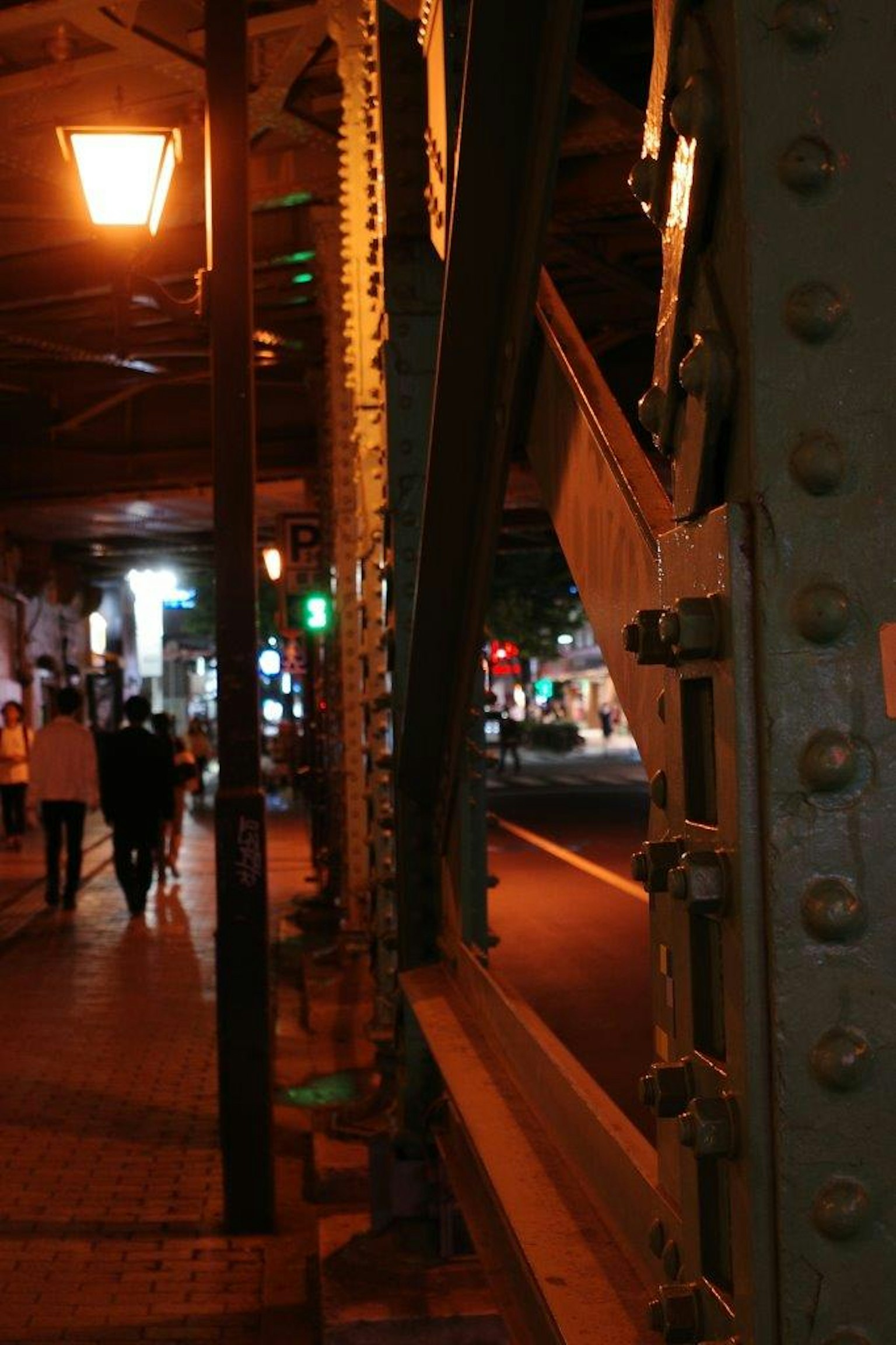 ฉากกลางคืนที่มีเสาค้ำรางรถไฟและโคมไฟถนน