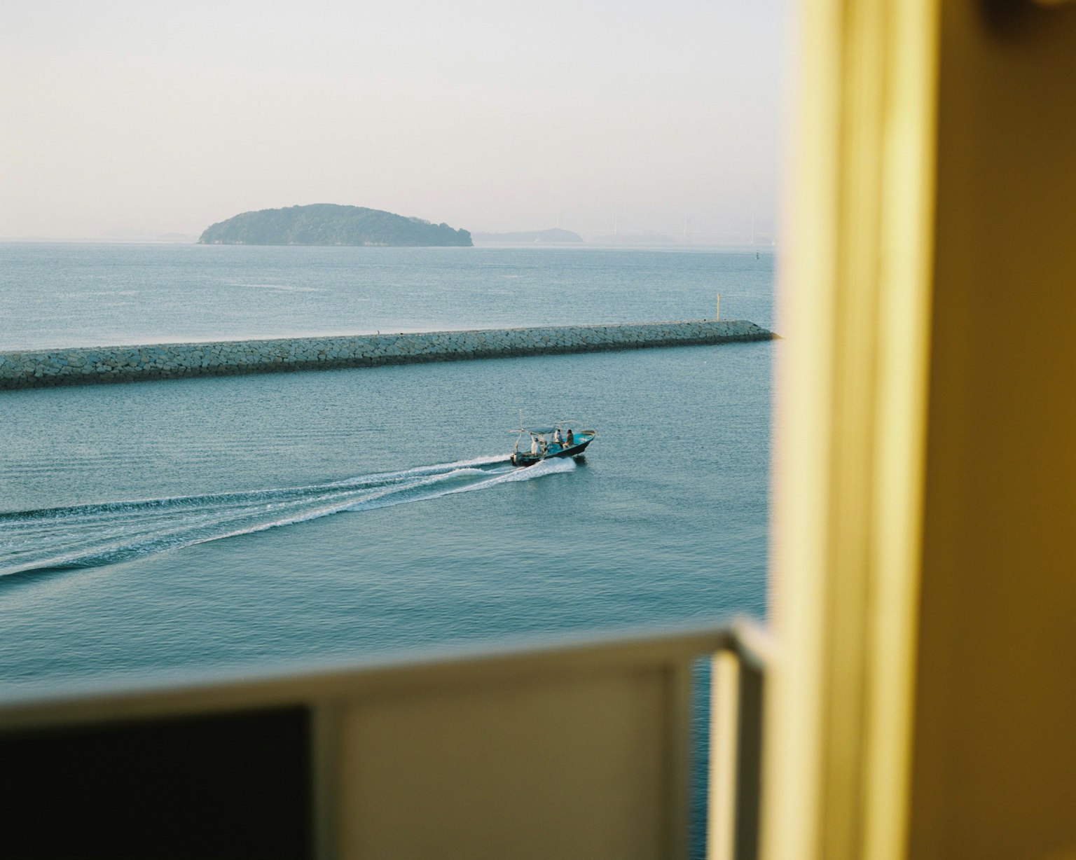Vue d'un bateau sur l'eau avec une petite île en arrière-plan
