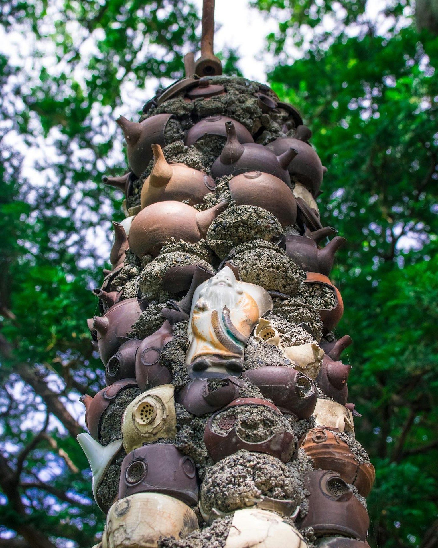 Tour de sculptures en poterie empilées sur fond vert