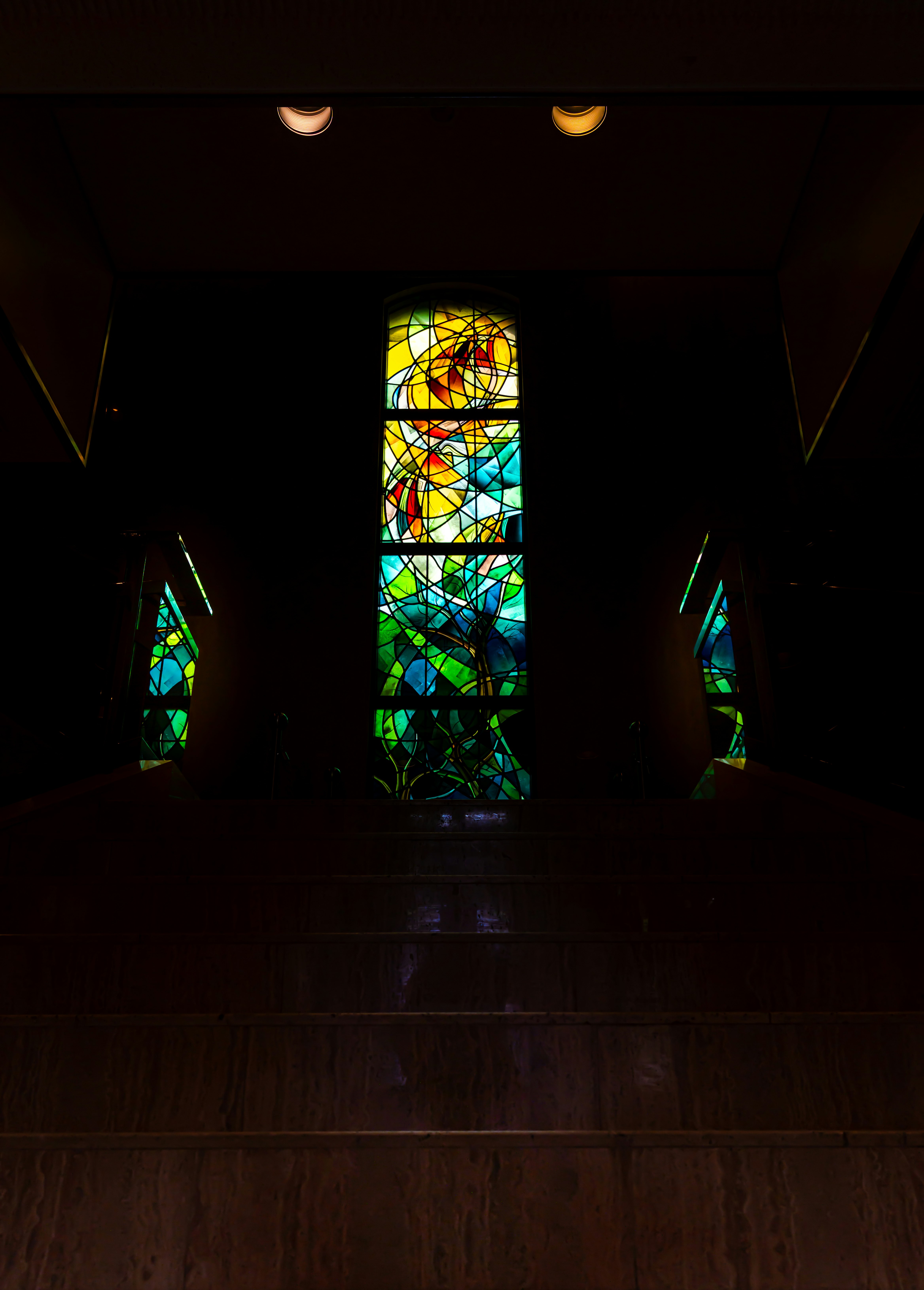 intérieur d’une chapelle sombre avec vitraux