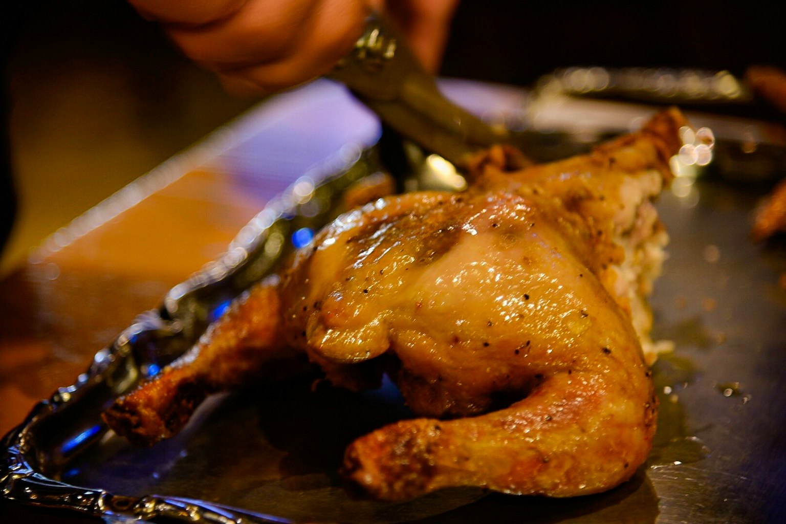 Close-up tangan memotong ayam panggang
