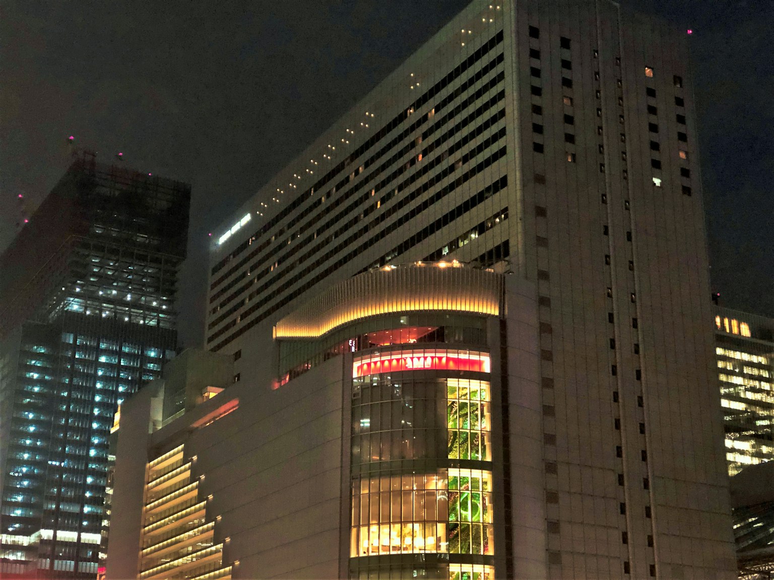 Immeuble de grande hauteur illuminé la nuit avec une signalisation vibrante