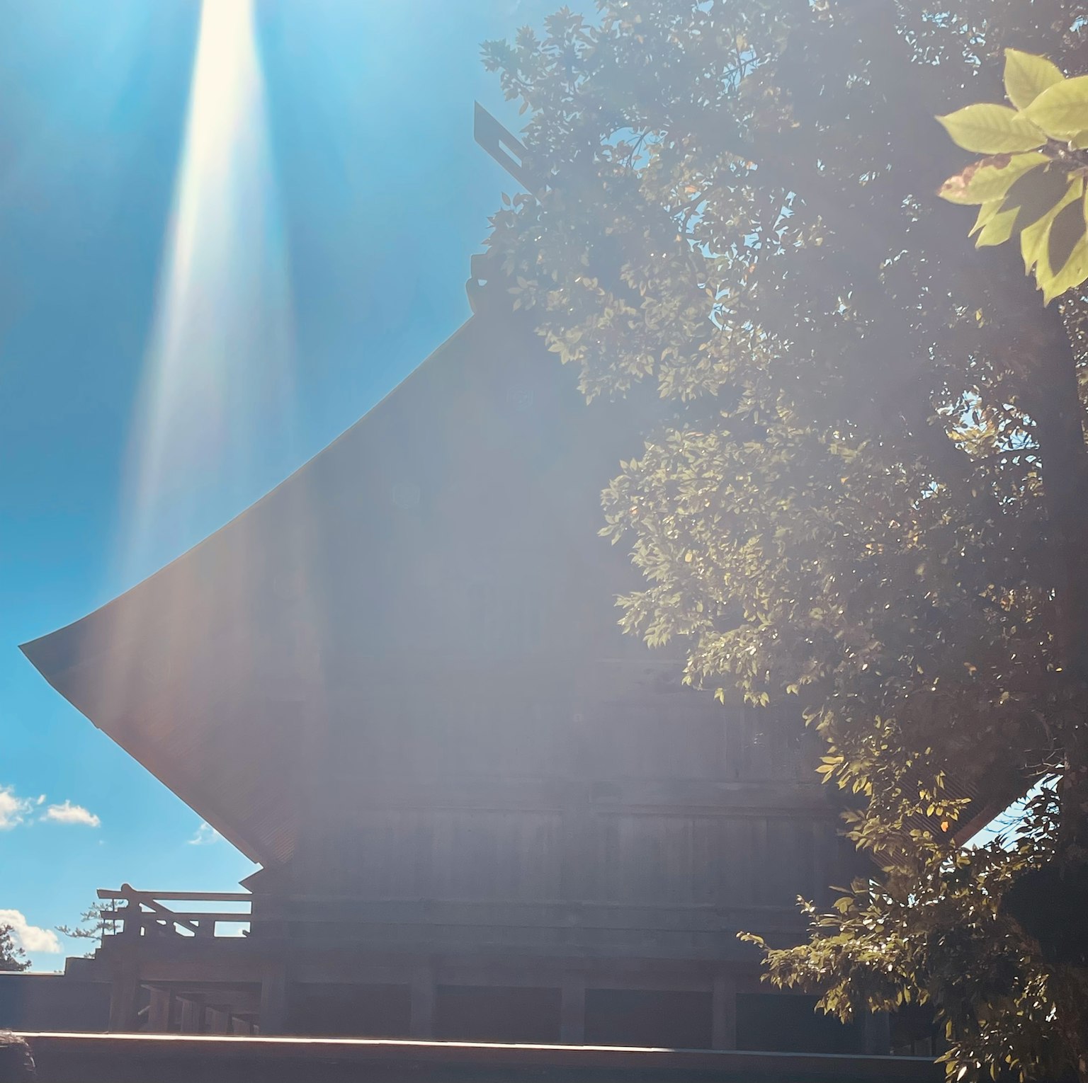 Silhouette di un edificio tradizionale sotto un cielo blu con un raggio di luce sullo sfondo