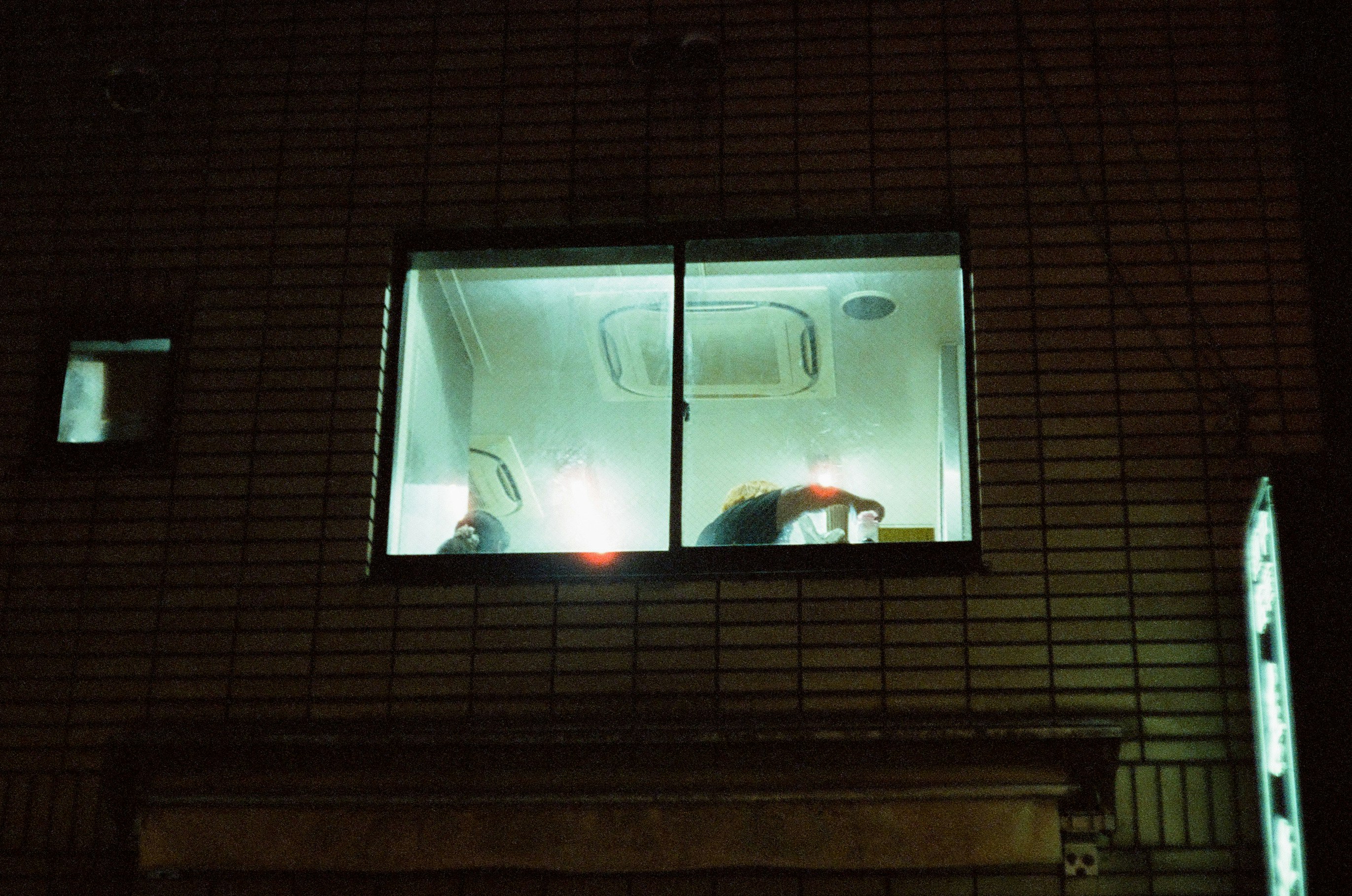夜のレンガ壁に映る窓の光