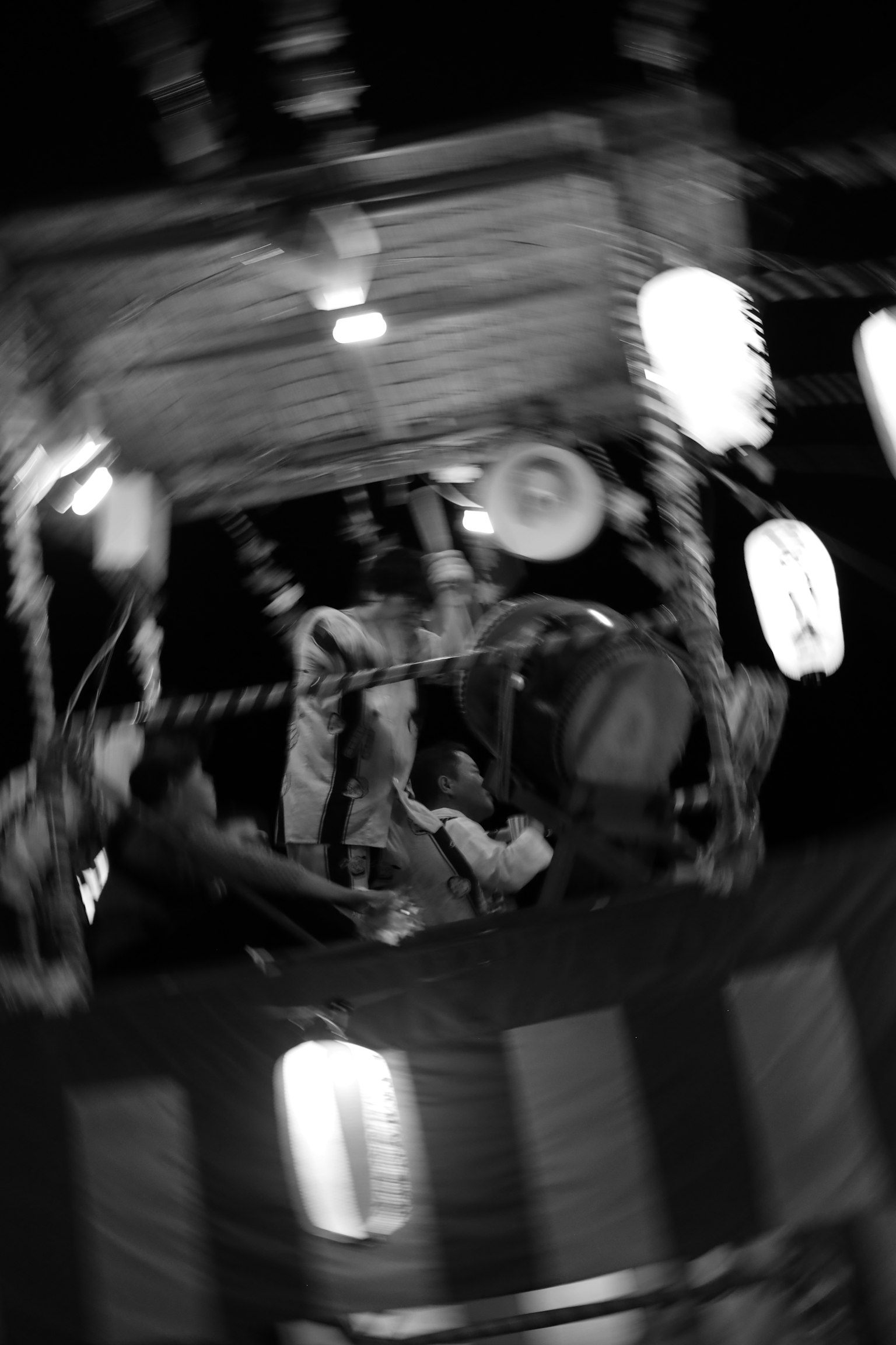 Scène de festival nocturne avec des lanternes lumineuses et des participants engagés dans des activités