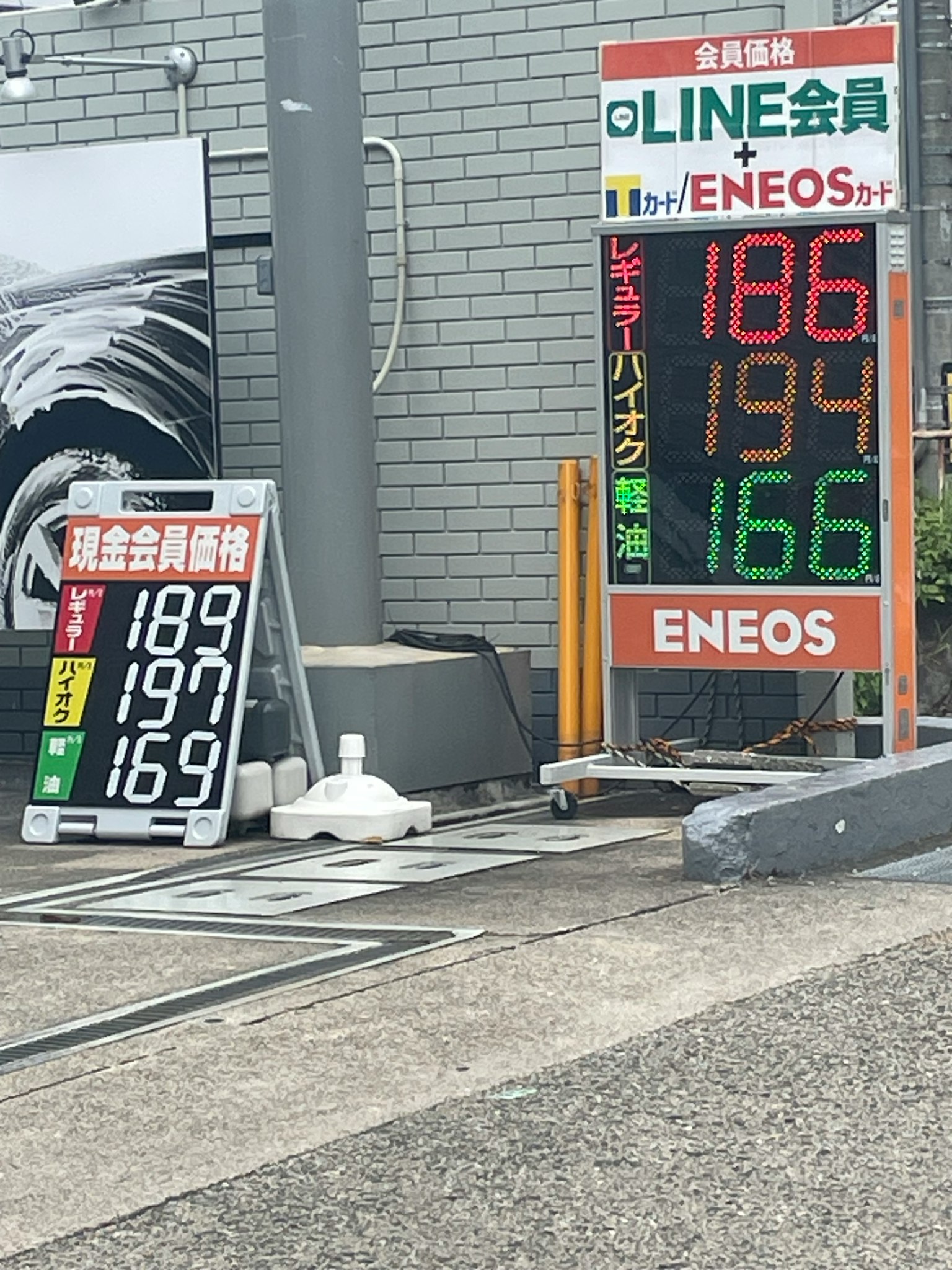 Preisanzeige an der ENEOS-Tankstelle mit grünem Preis 186 Yen rotem Preis 194 Yen blauem Preis 166 Yen