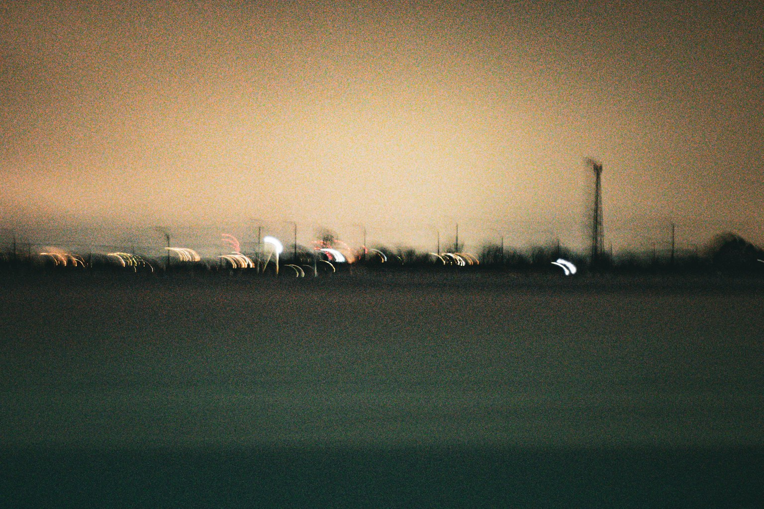 Verschwommene Nachtlandschaft mit entfernten Lichtern und sanften Farben