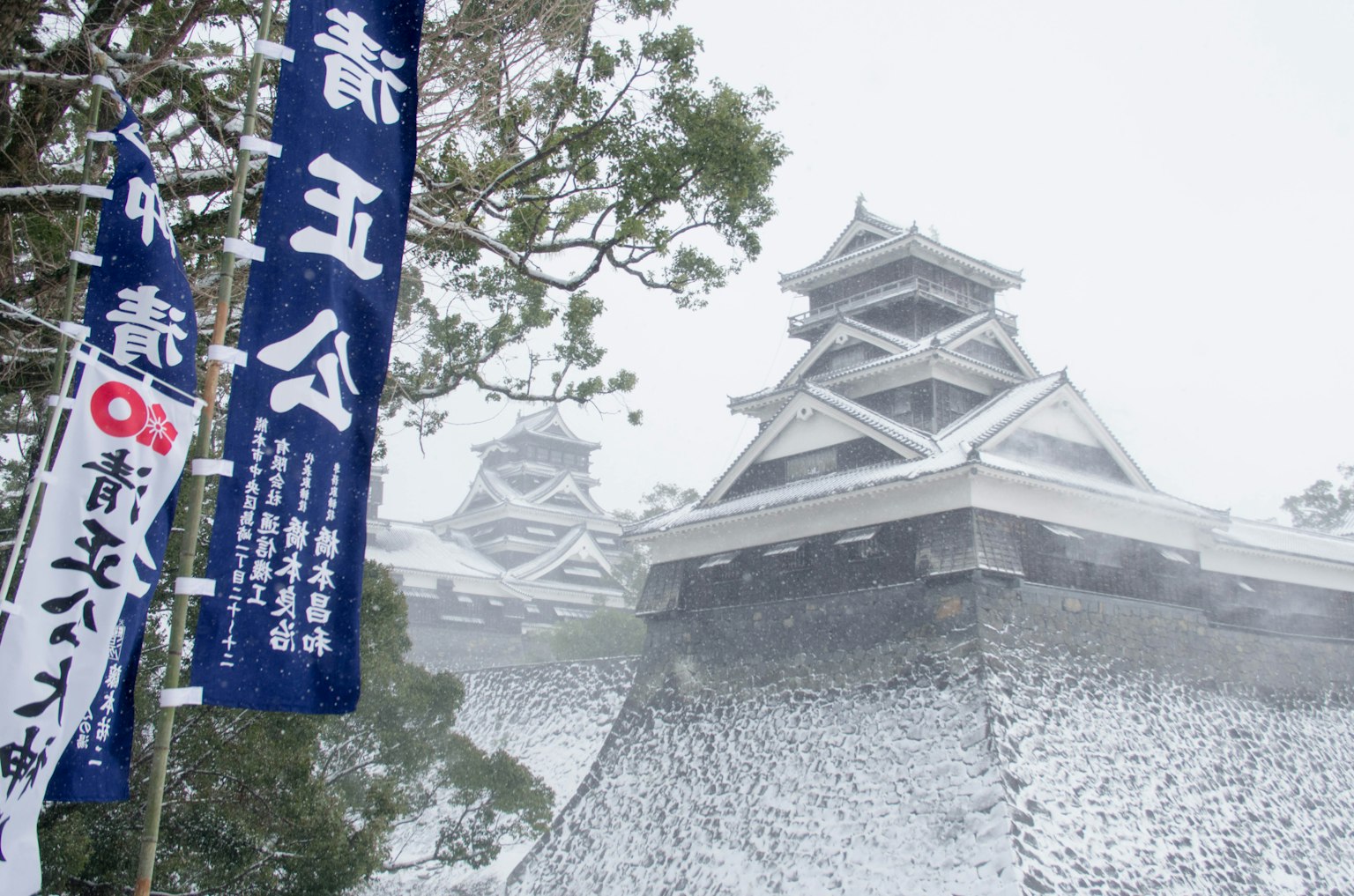 Pemandangan indah Kastil Matsumoto yang tertutup salju dengan spanduk biru