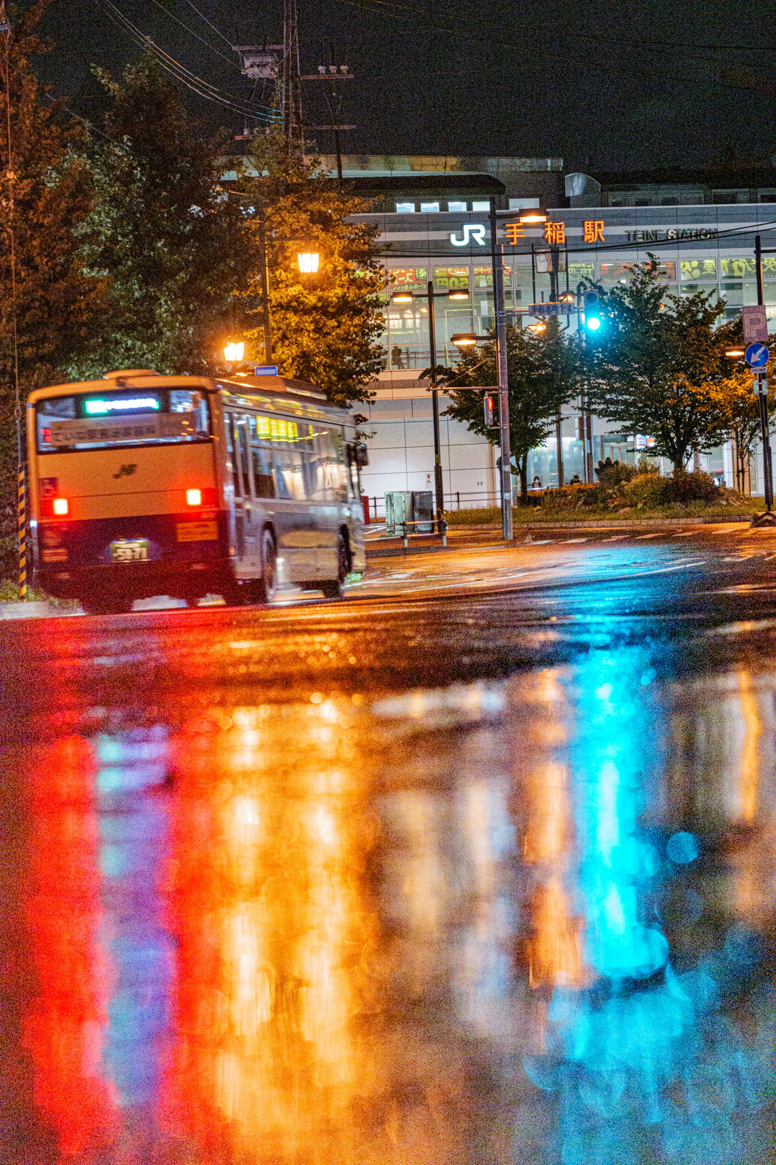 夜晚街道反射五彩斑斓的燈光和停靠的公車