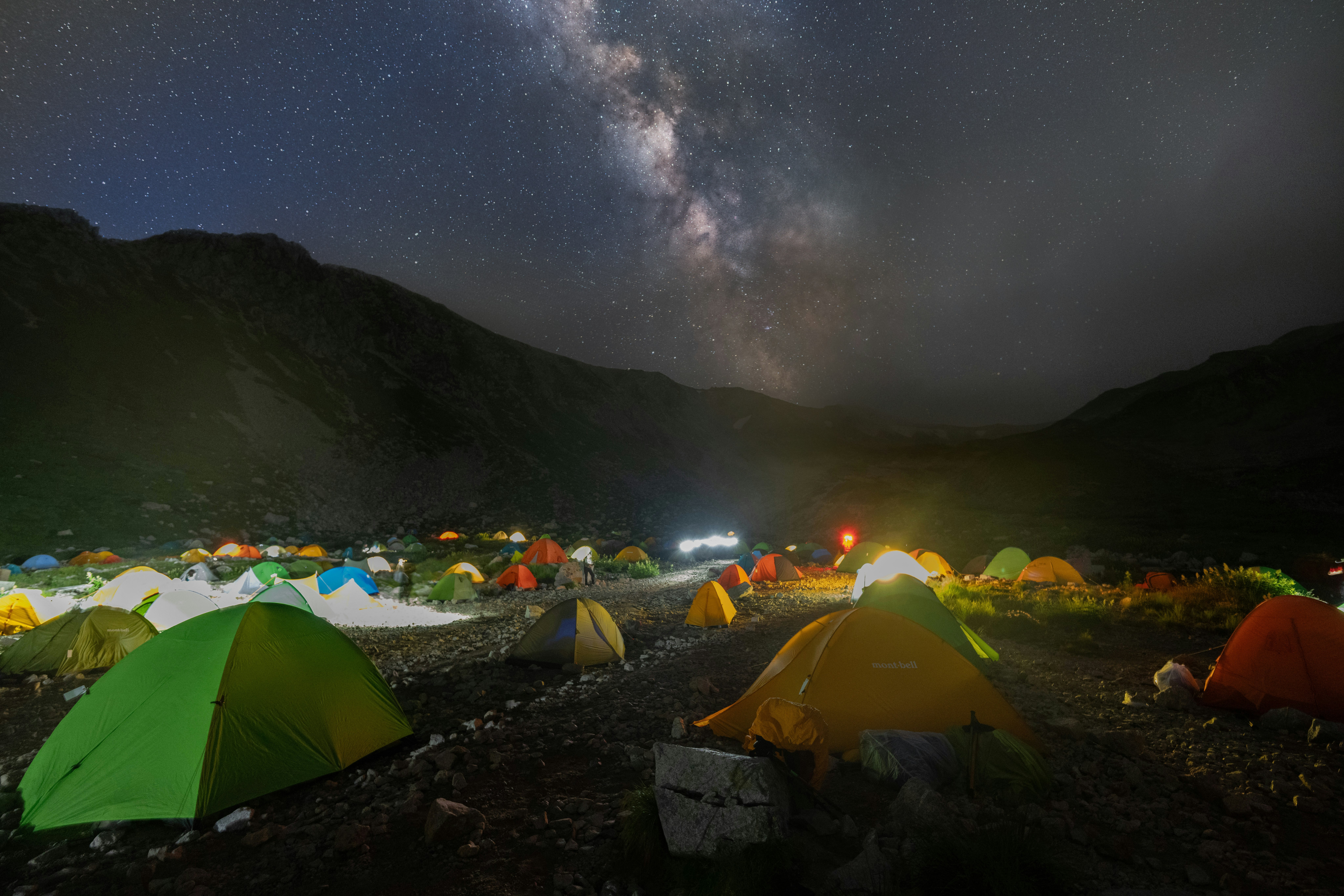 campamento de montaña con tiendas bajo un cielo estrellado