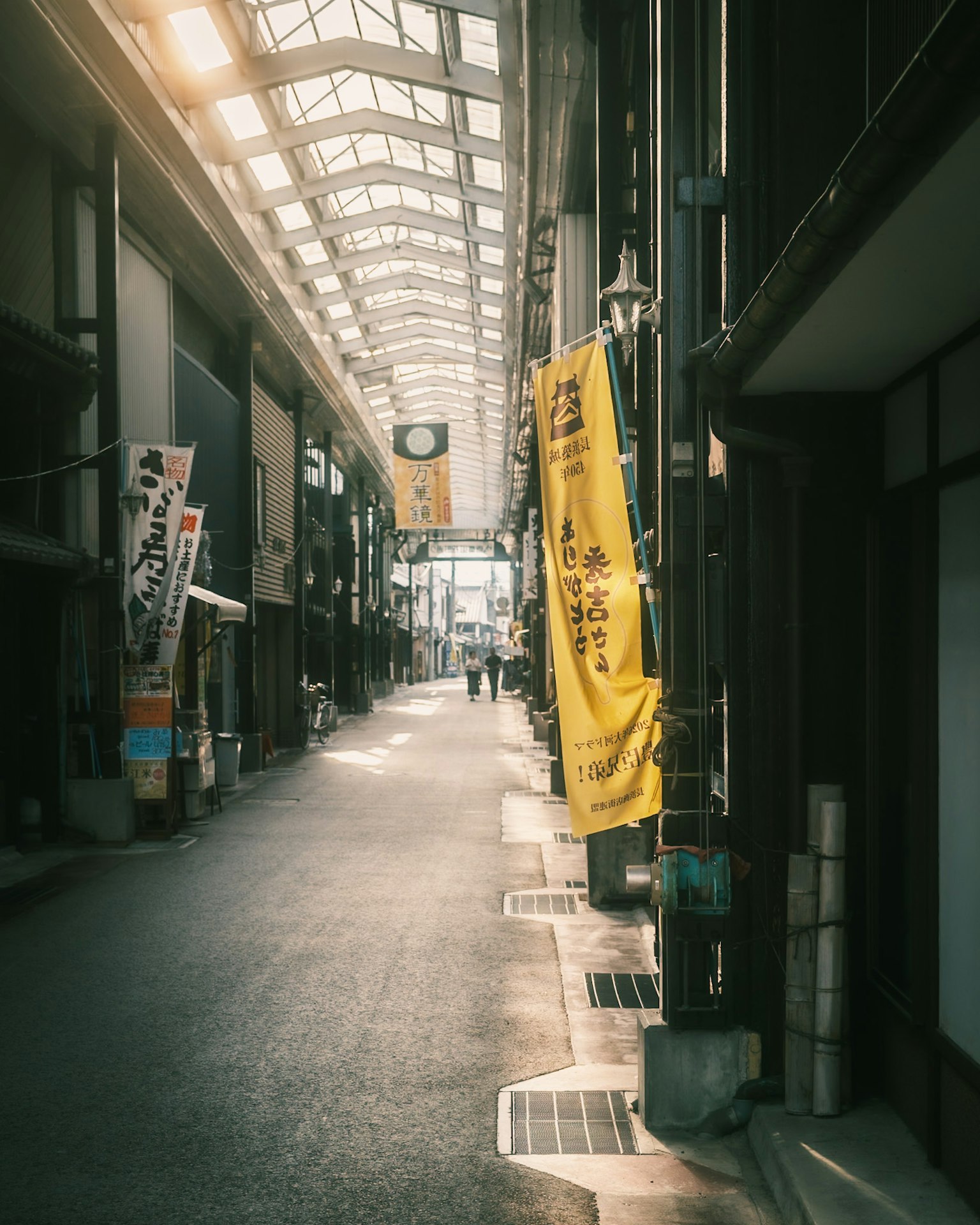 Scène de rue calme avec une longue arcade drapeaux jaunes suspendus