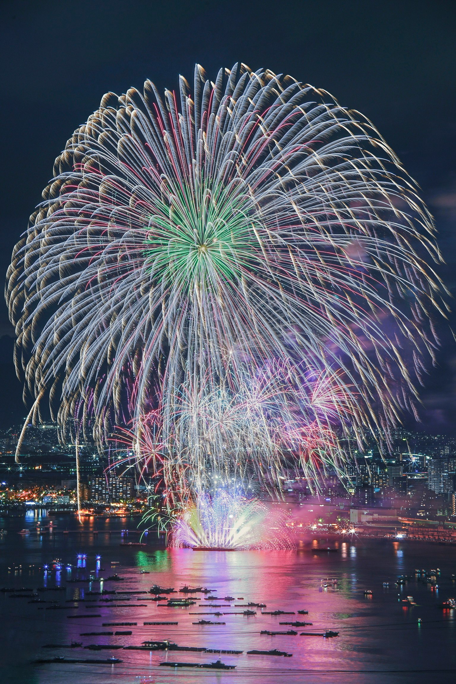 Fuochi d'artificio colorati che esplodono nel cielo notturno su un panorama urbano
