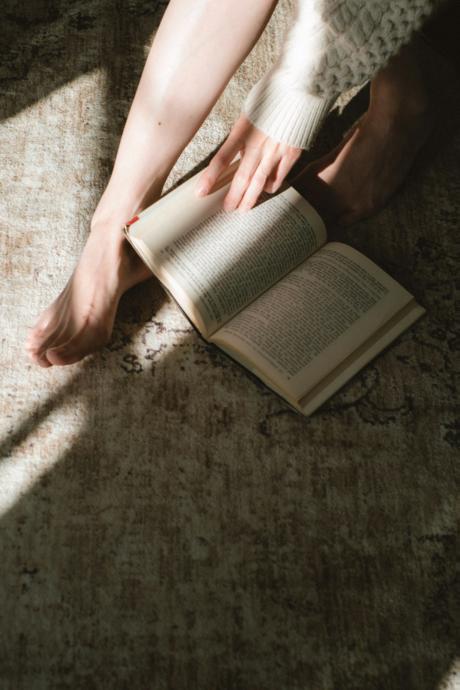 Scena di lettura rilassata con piedi e un libro aperto