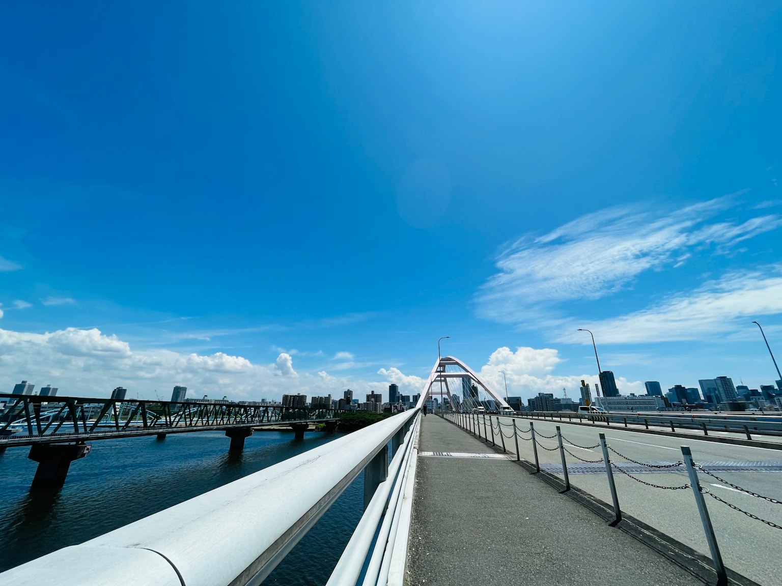 Paisaje urbano con un puente blanco contra un cielo azul