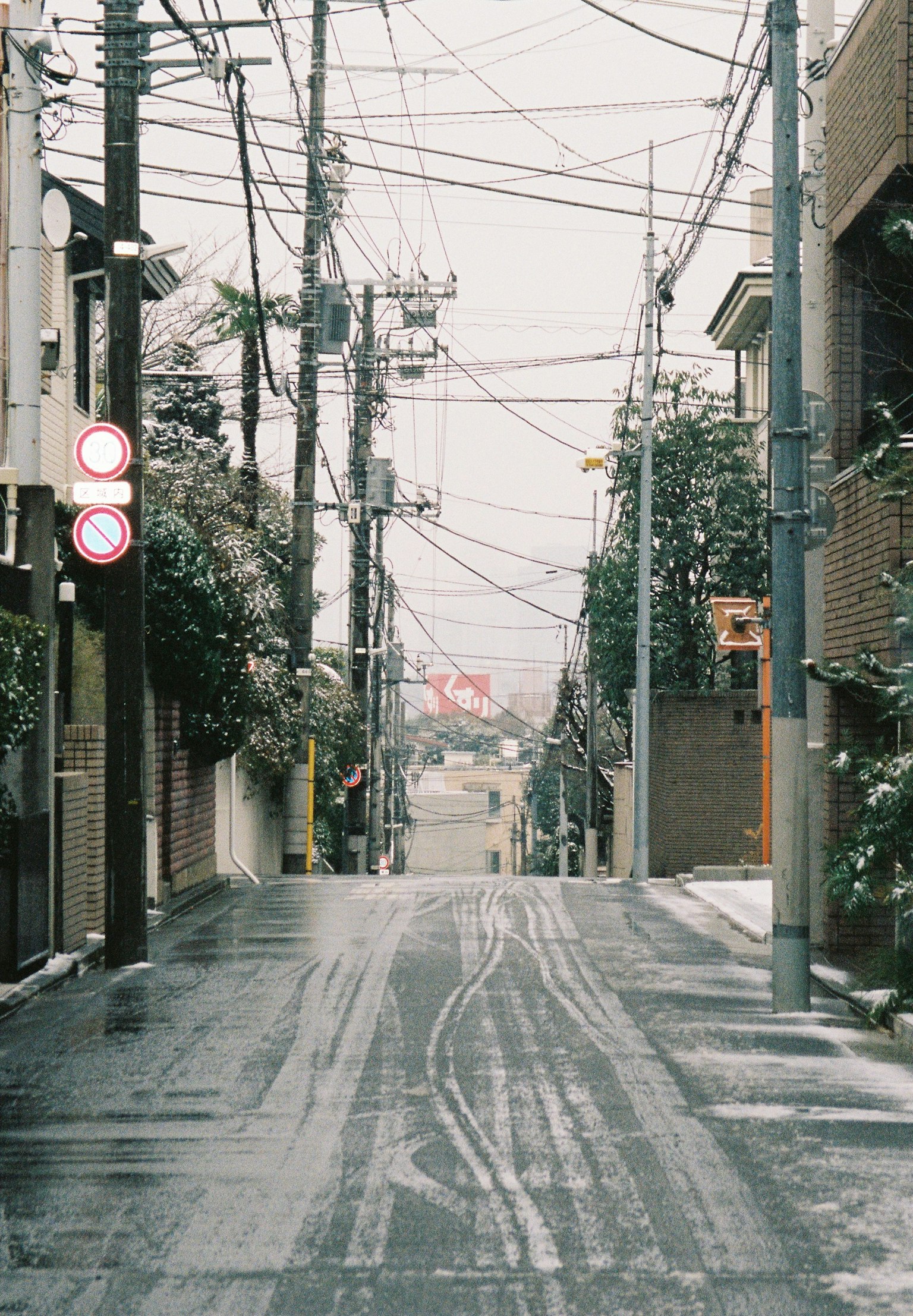 Jalan tenang bersalju di Tokyo dengan kabel listrik