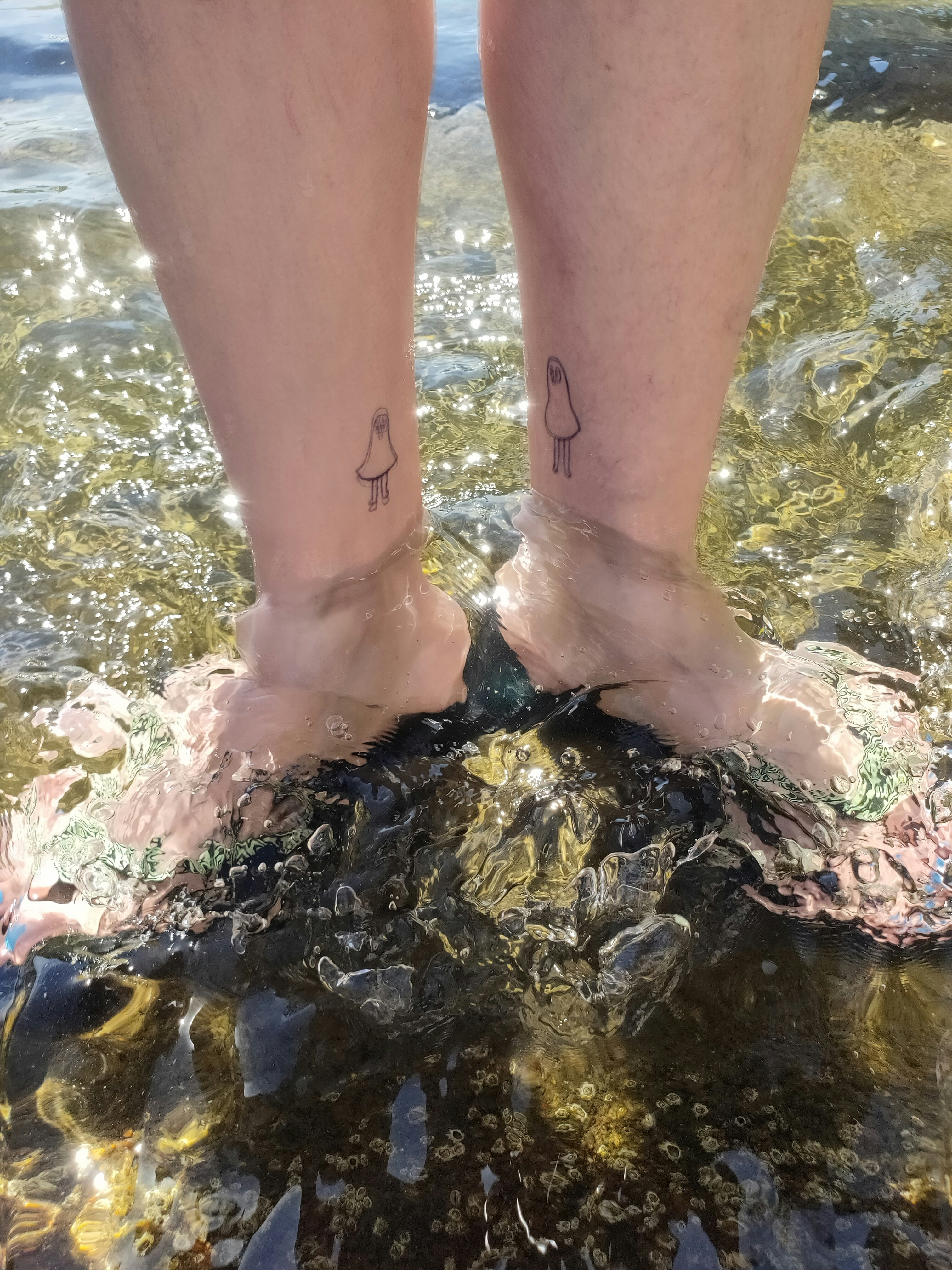海辺の浅瀬で水遊びする足元の波しぶき